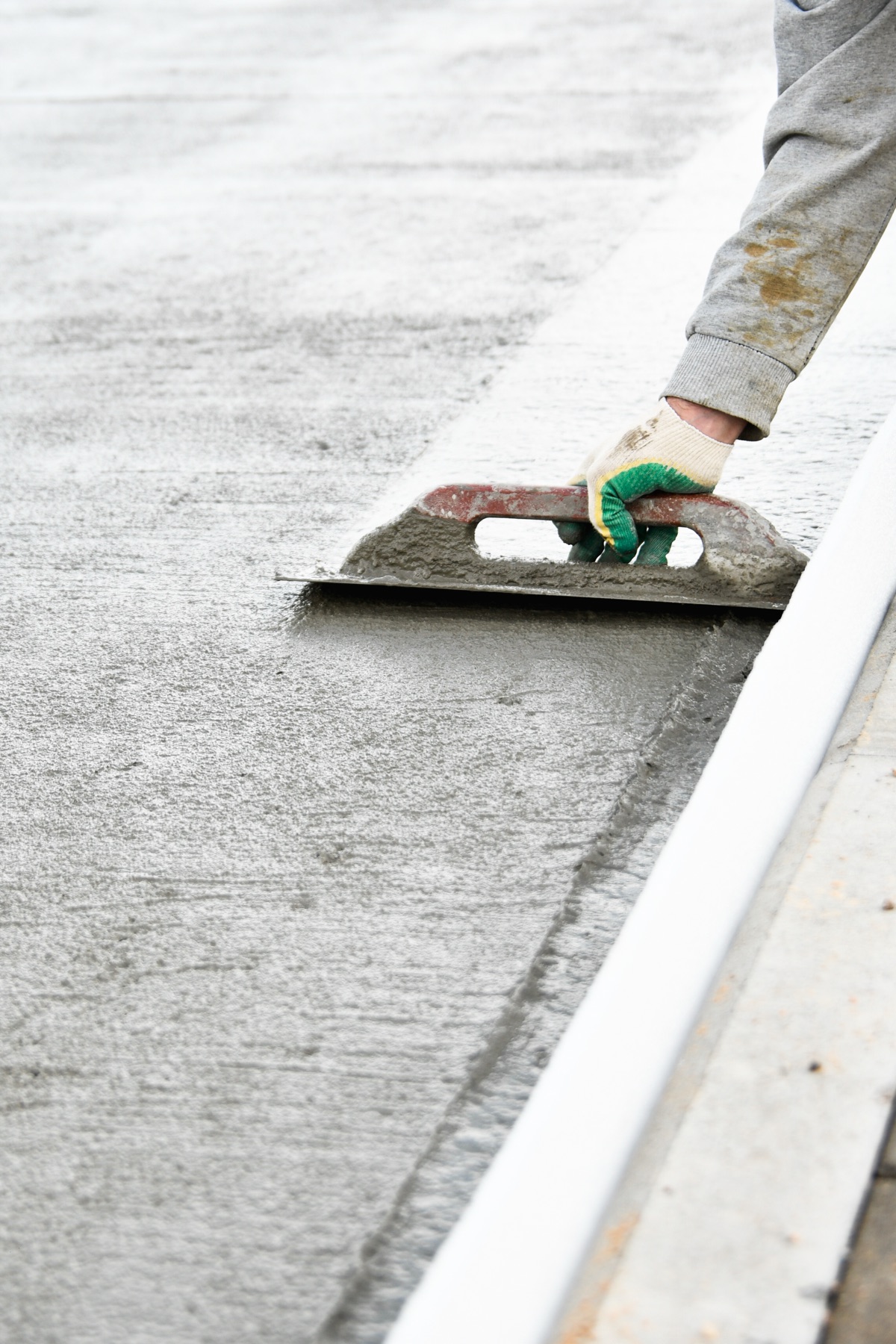 Fresh concrete being floated smooth on a Paiz Builders flatwork pour