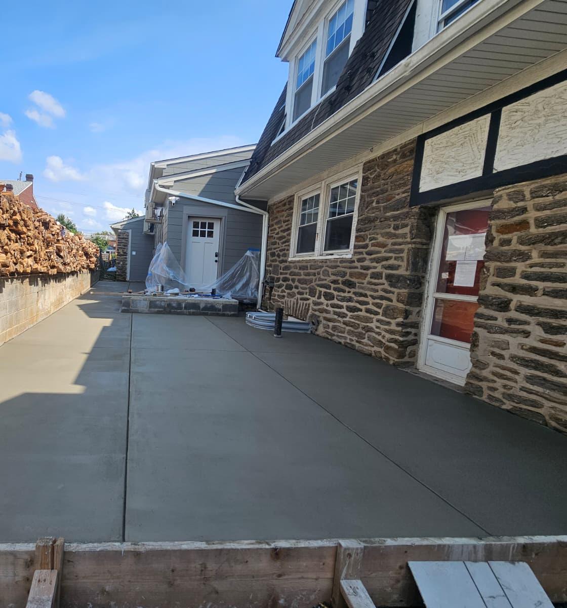 Finished concrete pad with control joints running along the stone house