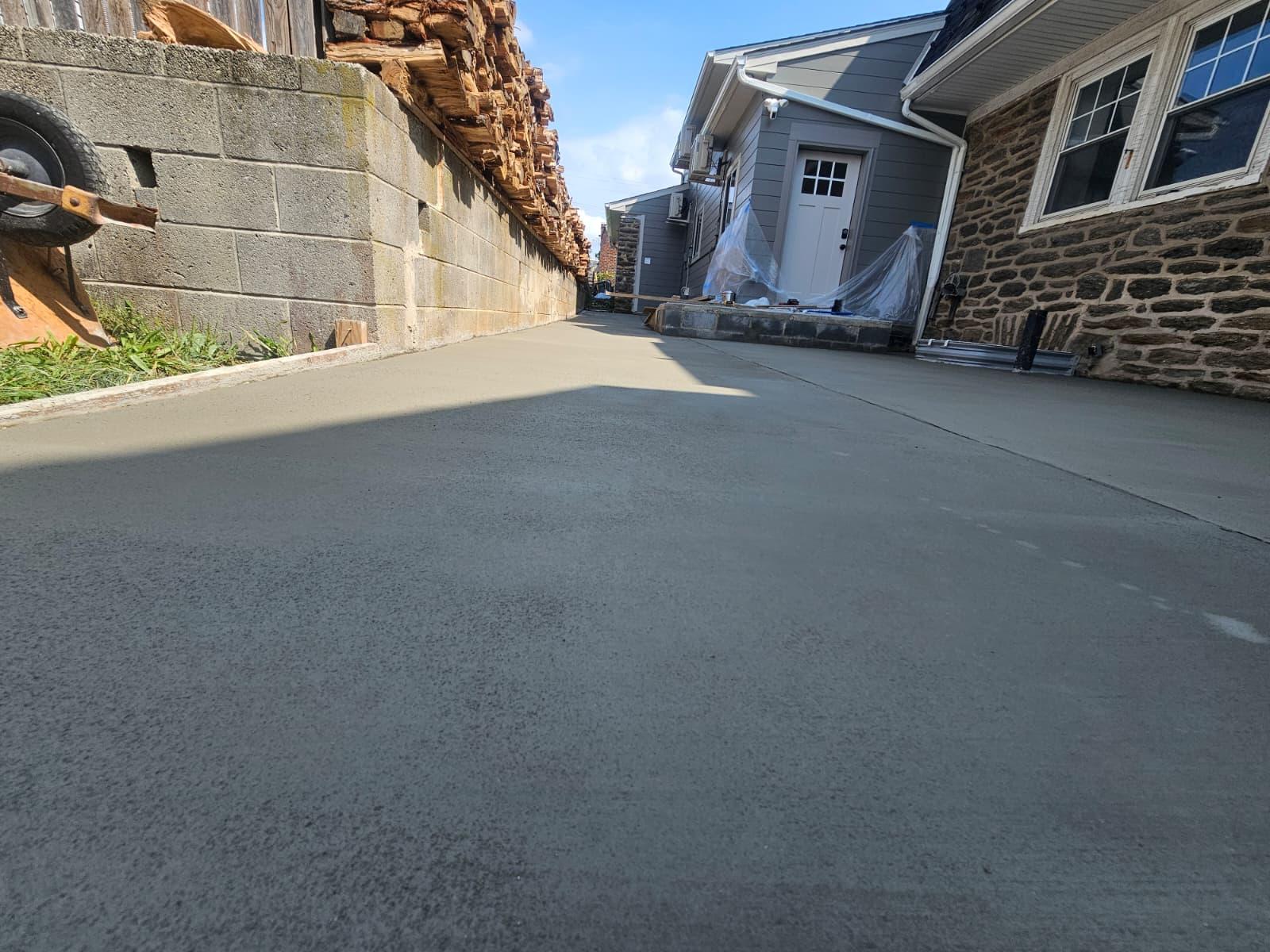 Broom finish texture on the new concrete slab beside the block wall
