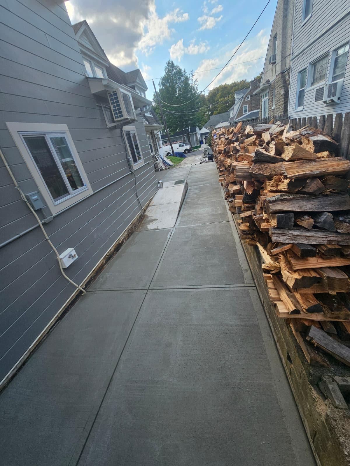 Finished concrete side walkway running between the house and the retaining wall