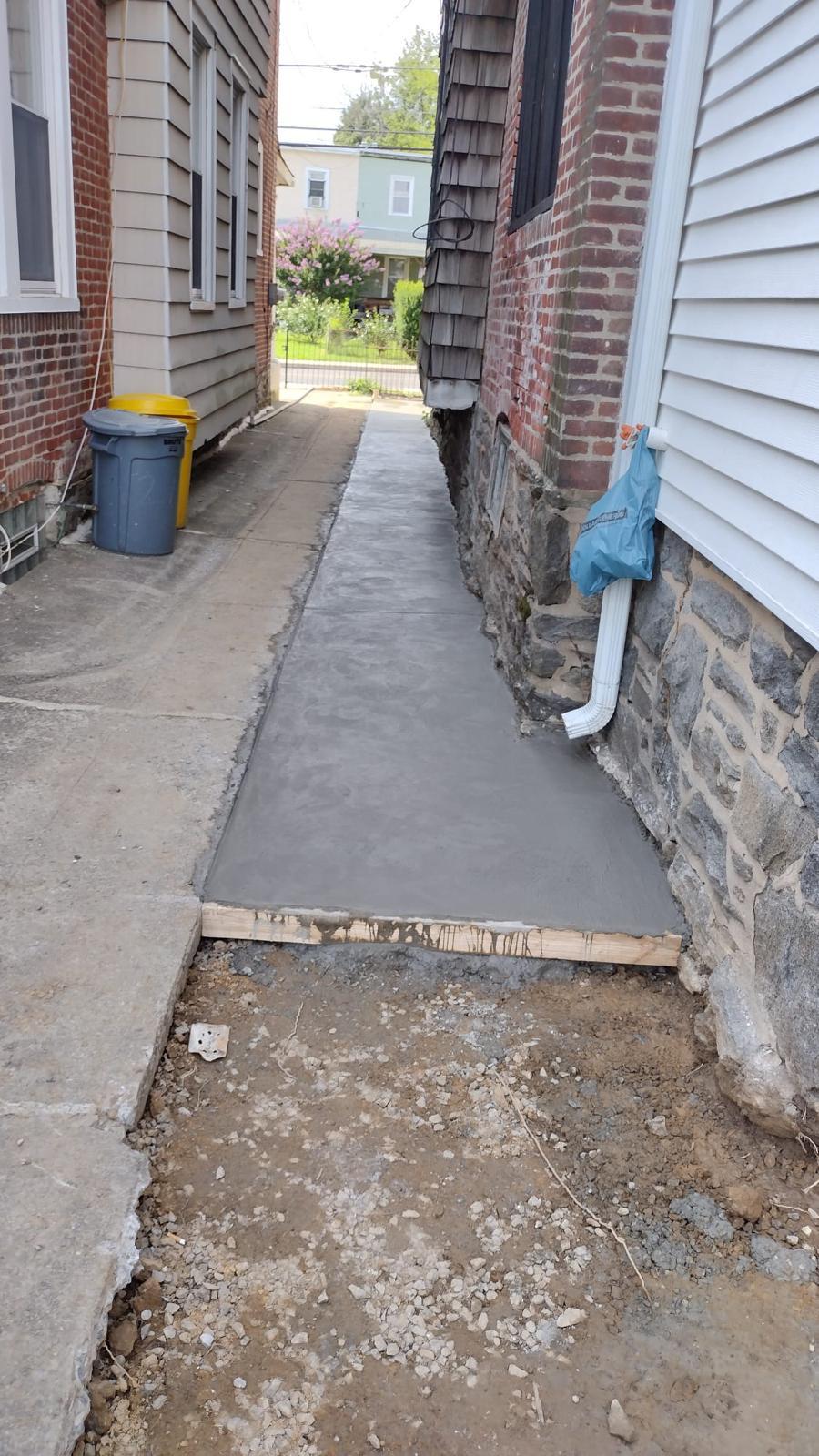 Broom-finished concrete walkway running between two homes to the street