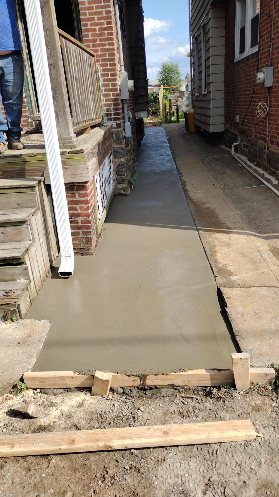 Freshly poured concrete walkway between two twin homes