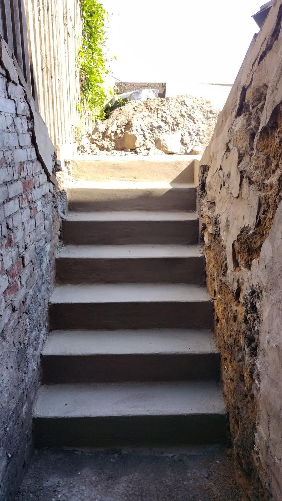 New poured concrete steps leading up from a basement entry