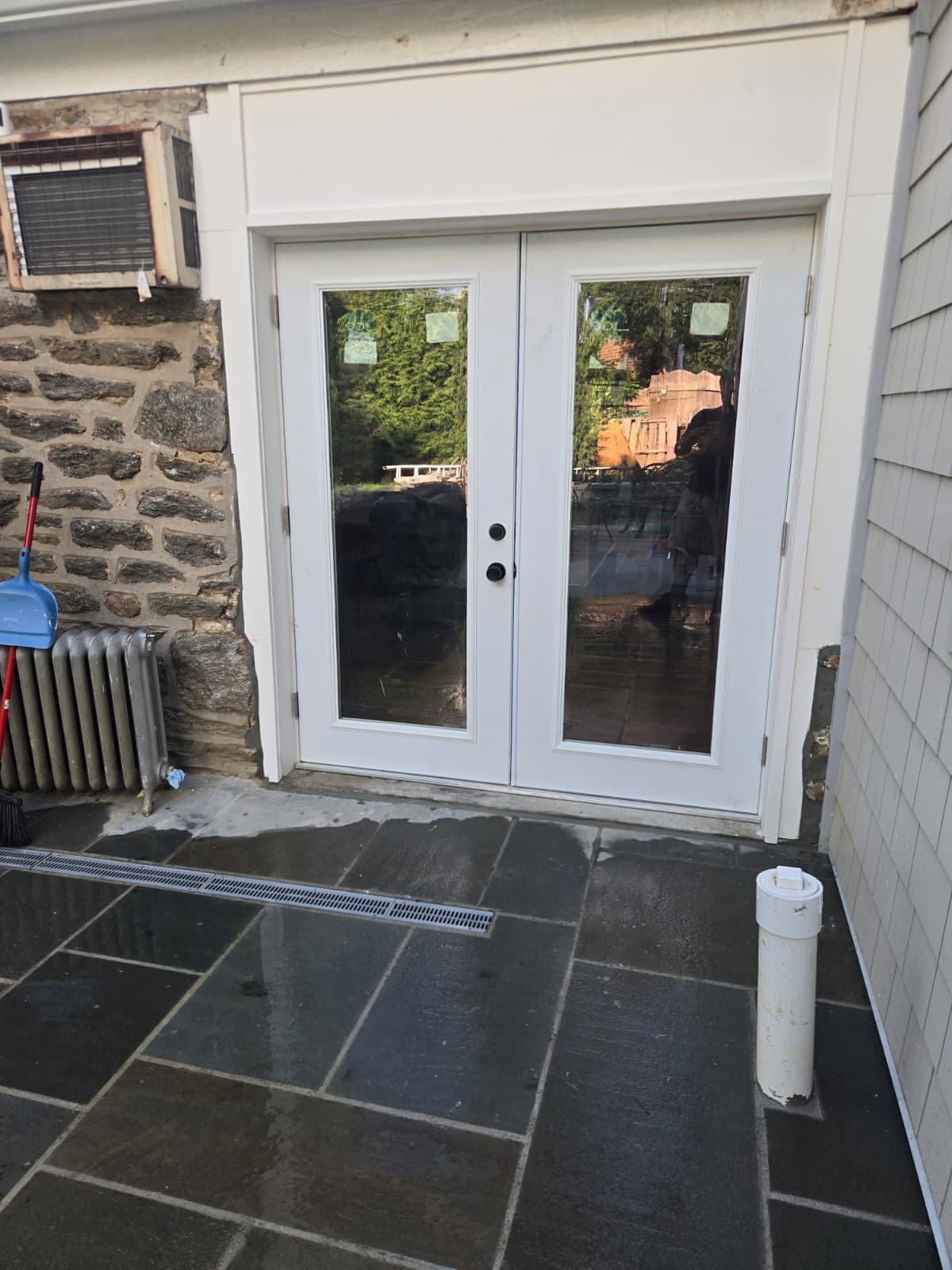 New white French doors installed in the stone facade