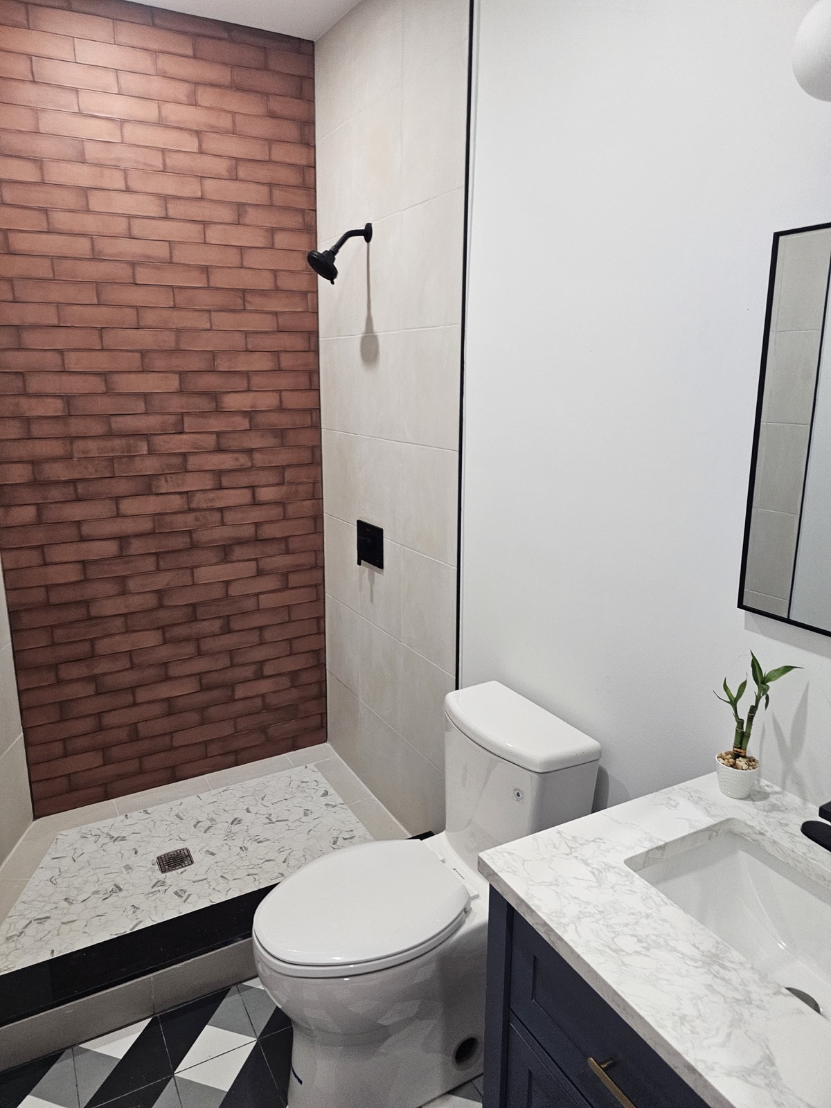 Brick-look walk-in shower with black fixtures
