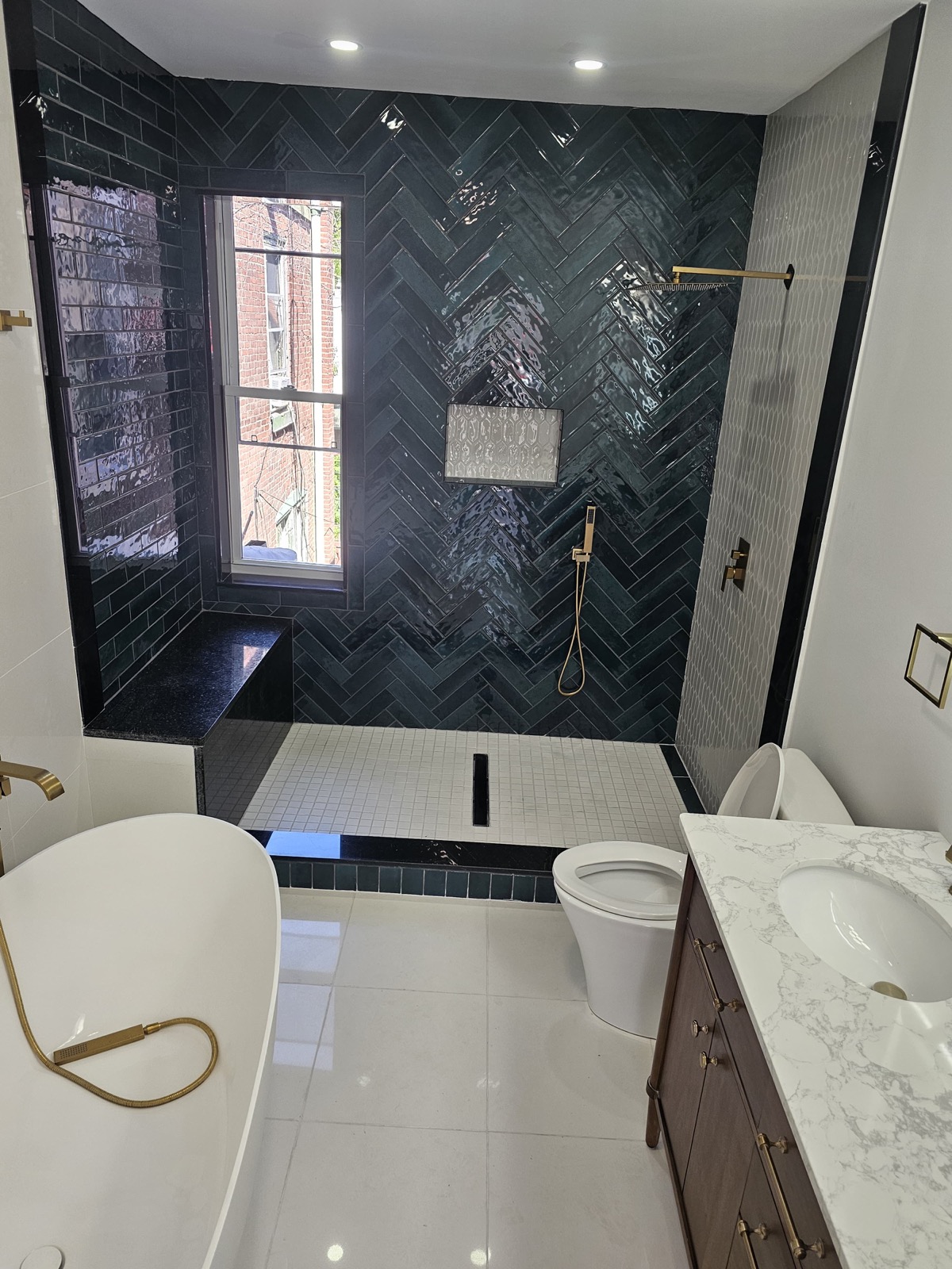 Green herringbone shower beside the freestanding tub