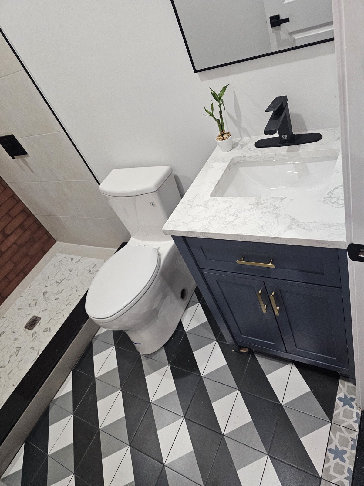Navy vanity with geometric black-and-white floor tile