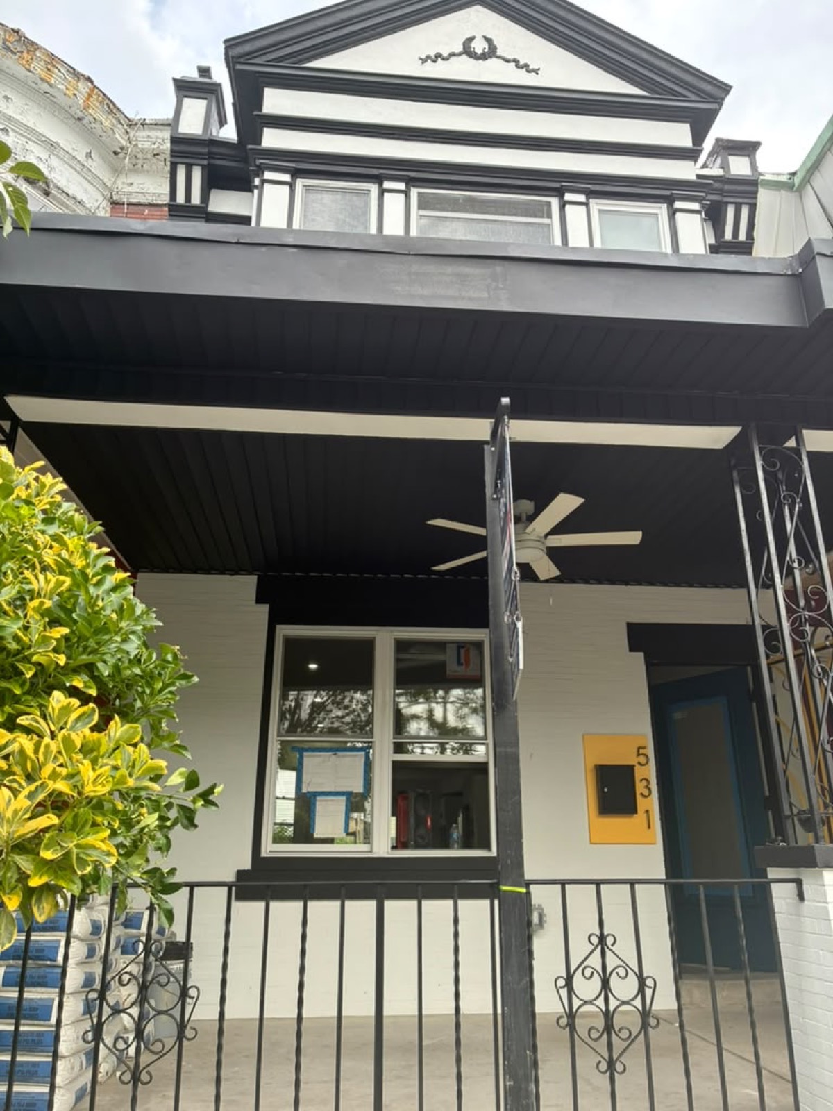 Restored porch with ceiling fan on the renovated rowhouse