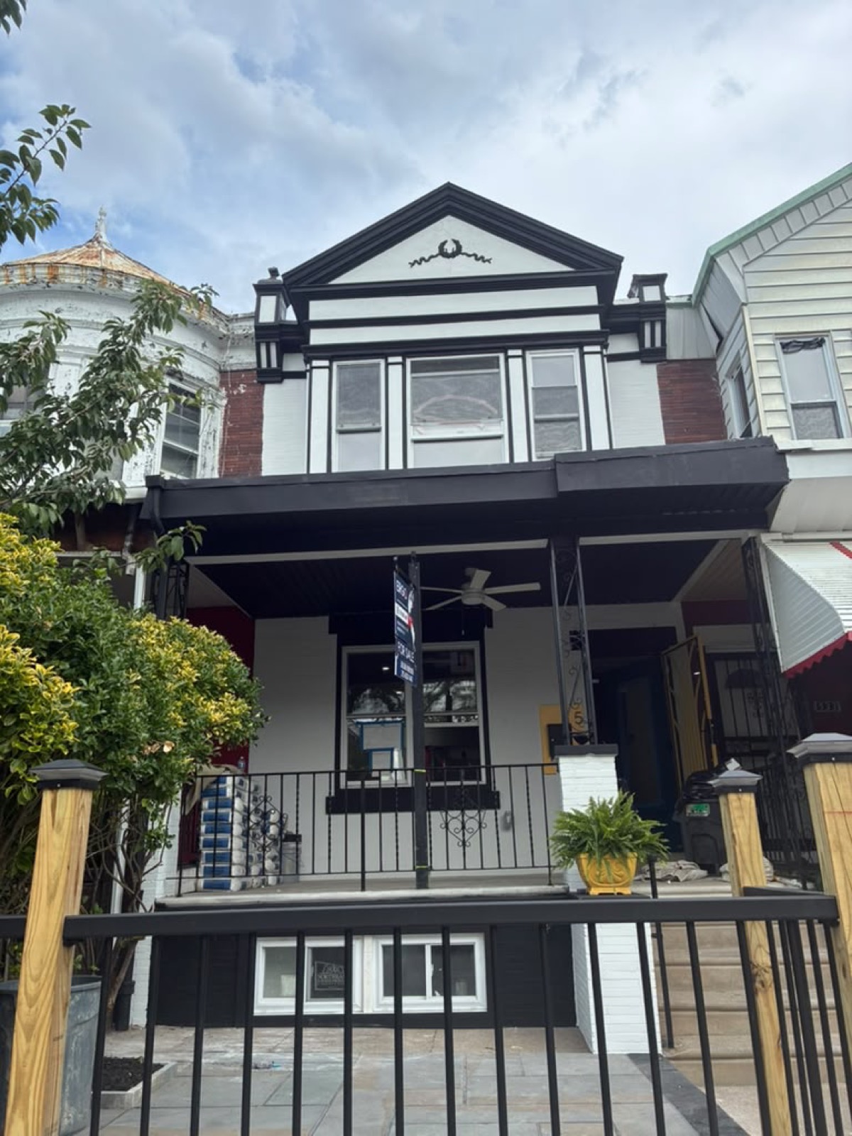 Repainted black and white rowhouse facade with ornate pediment
