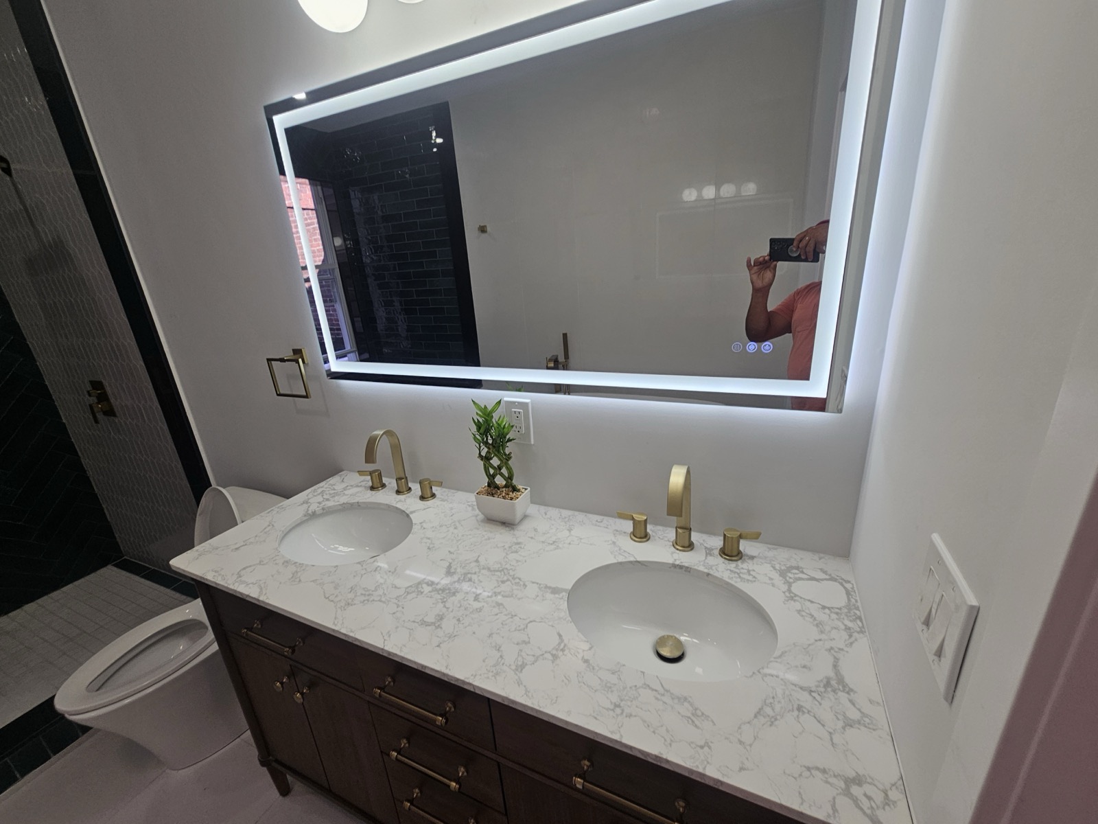 Walnut double vanity with marble top and brass faucets