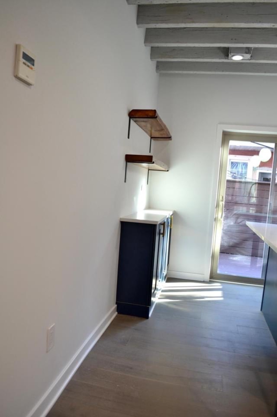 Navy cabinetry with reclaimed wood shelving by the deck door