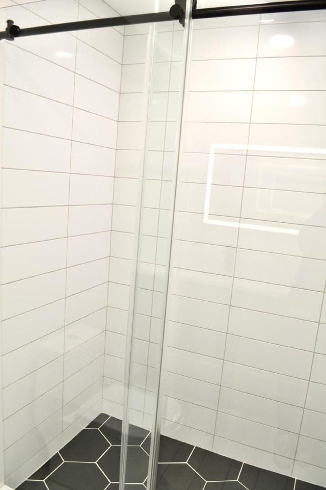 Glass shower with white subway tile