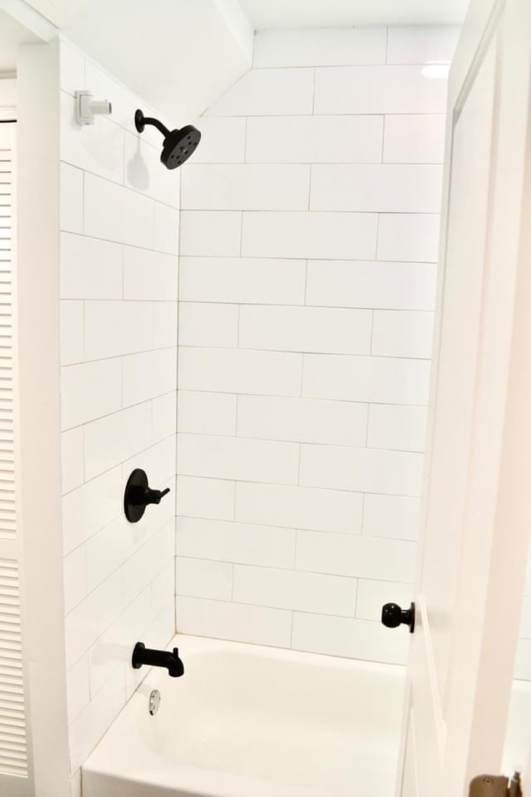 Tub shower with white subway tile and matte black fixtures
