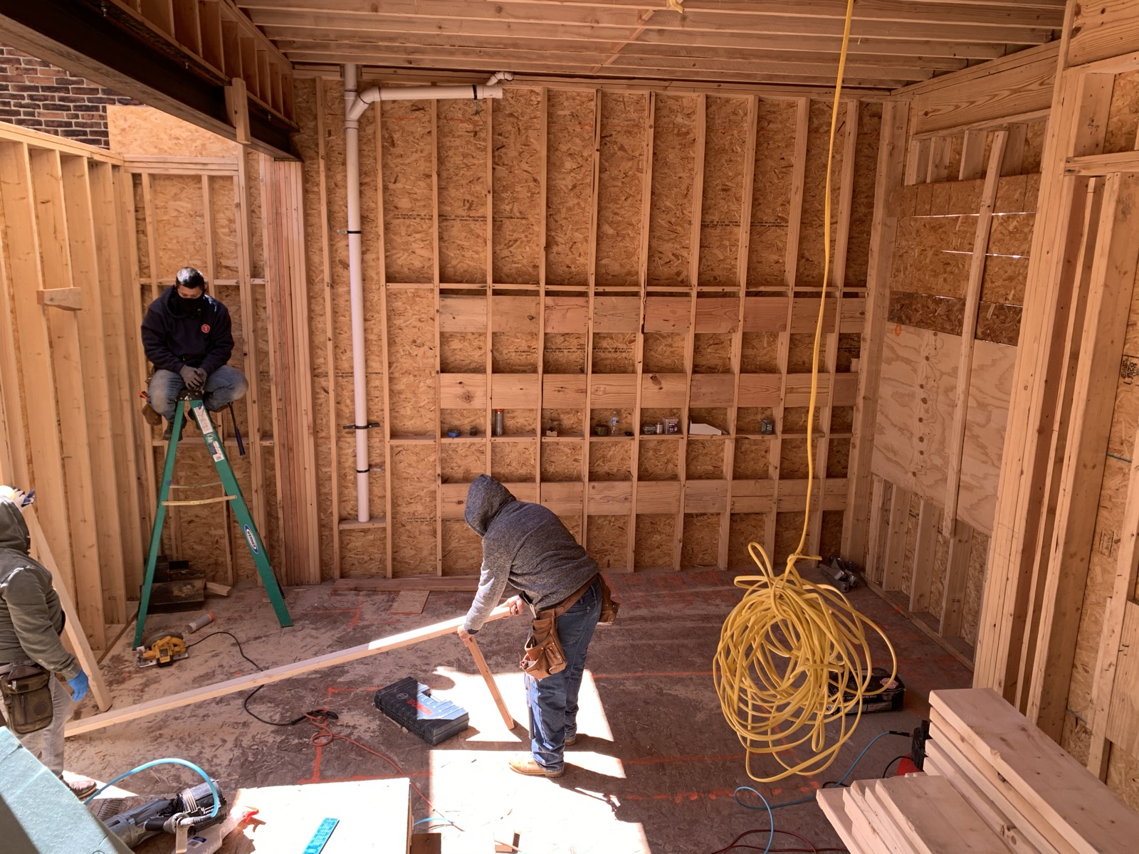 Crew laying out lumber in a framed room