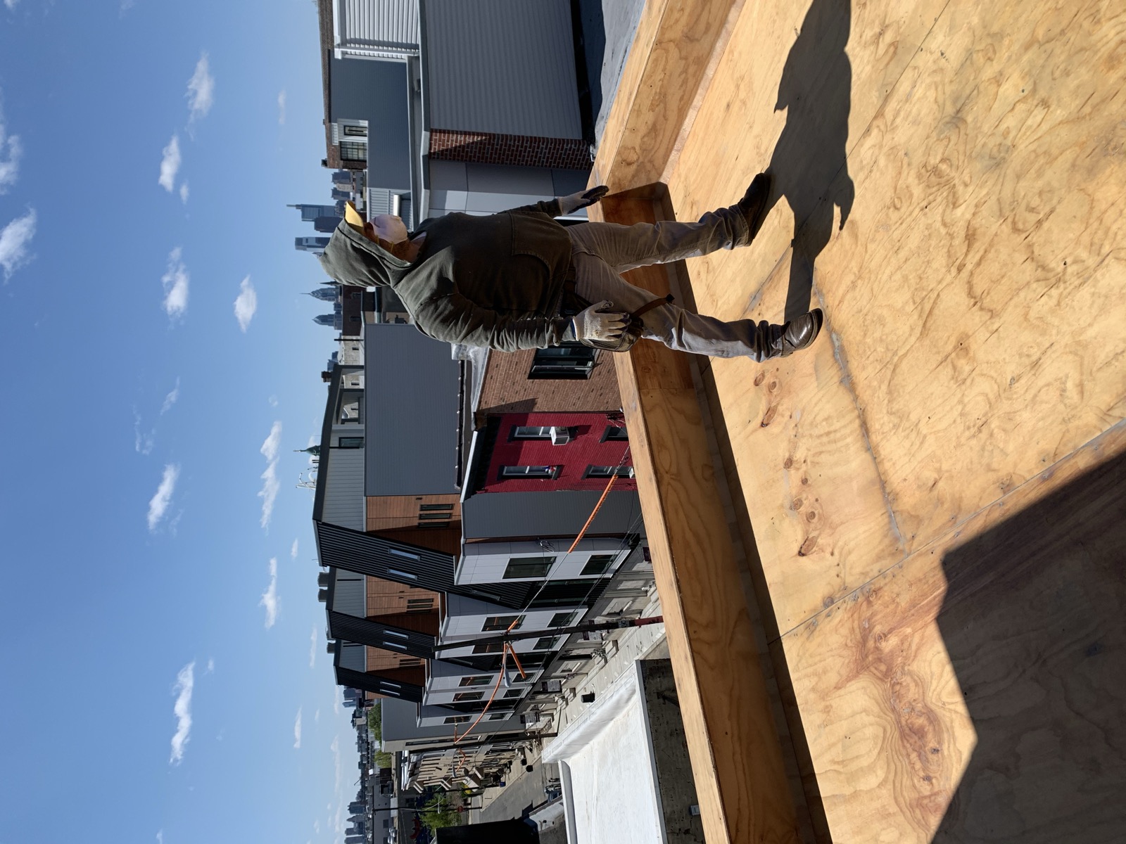 Crew member on a framed roof deck with the Philadelphia skyline behind