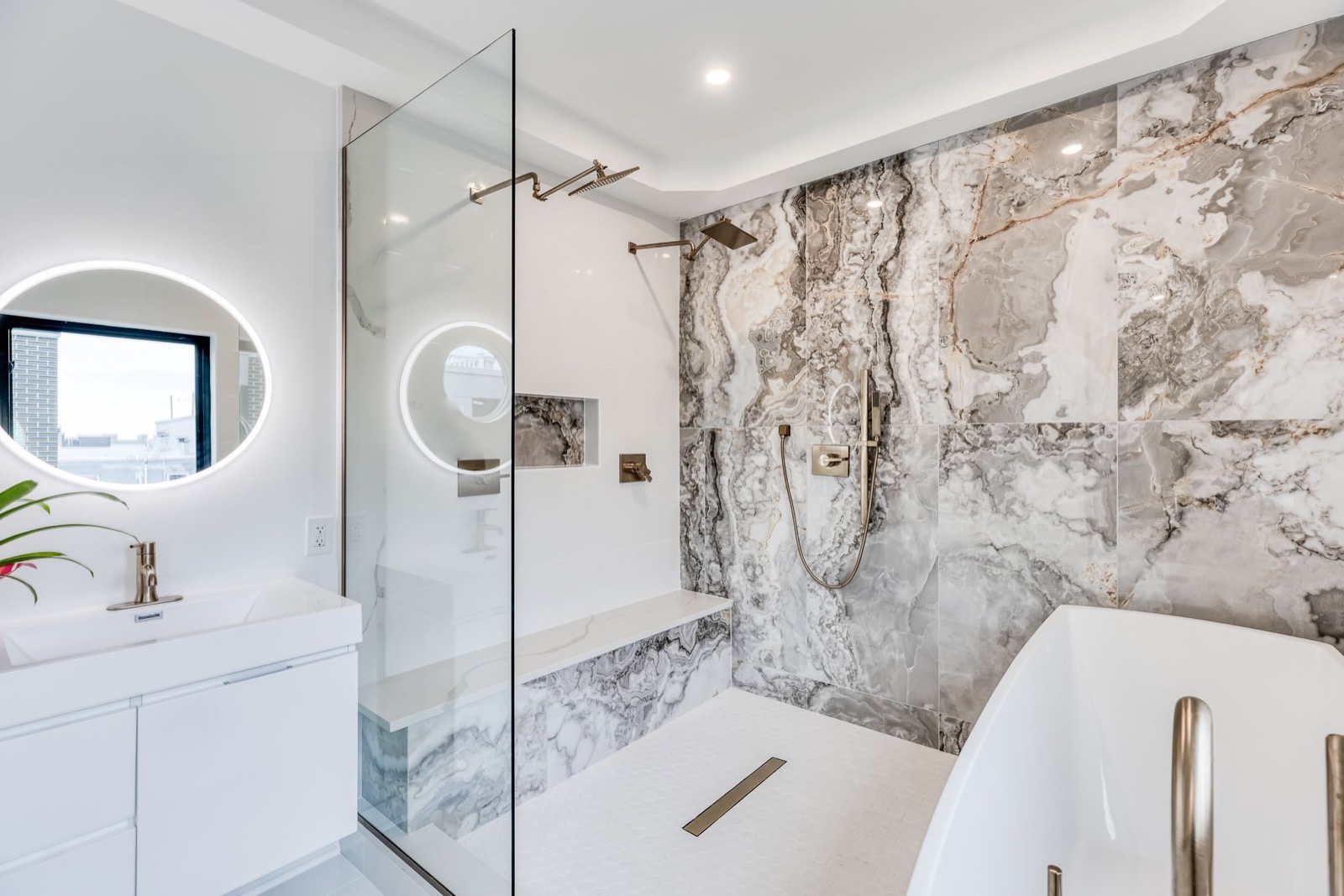 Marble shower with brass rain heads and bench
