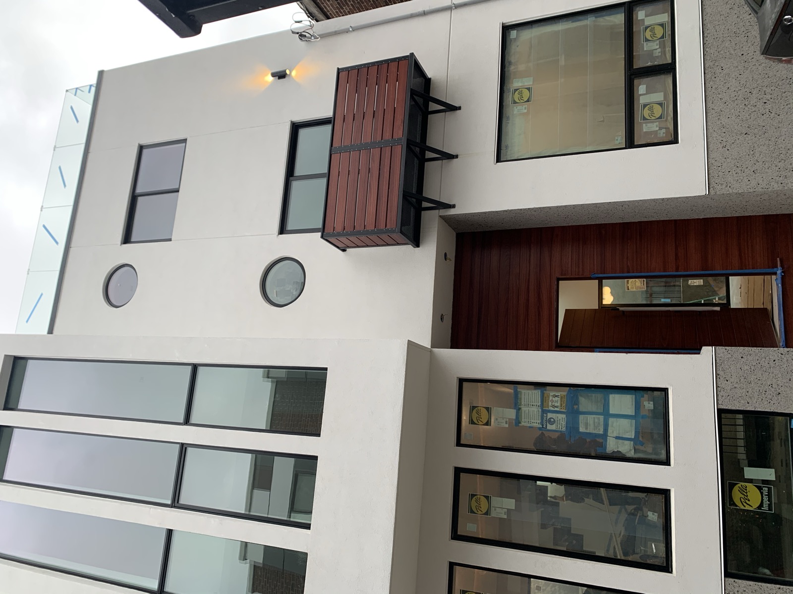 Modern stucco facade with round windows at the Kensington luxury townhome