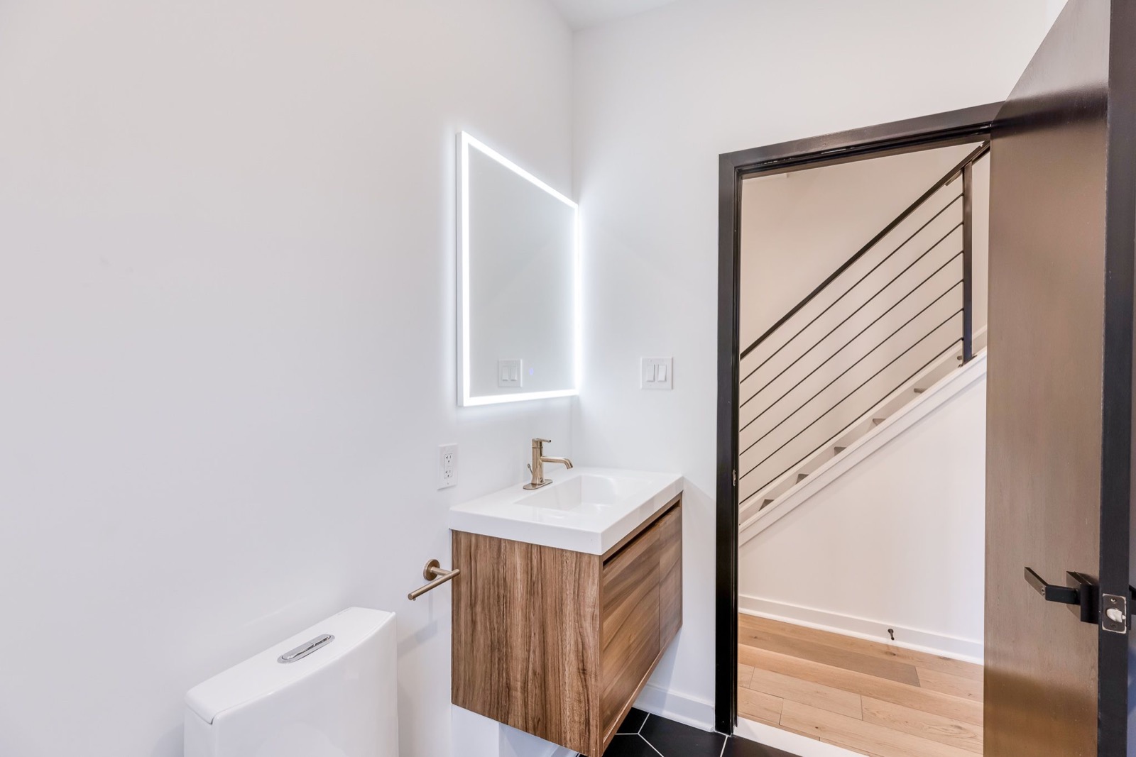 Walnut floating vanity with LED mirror in the guest bath