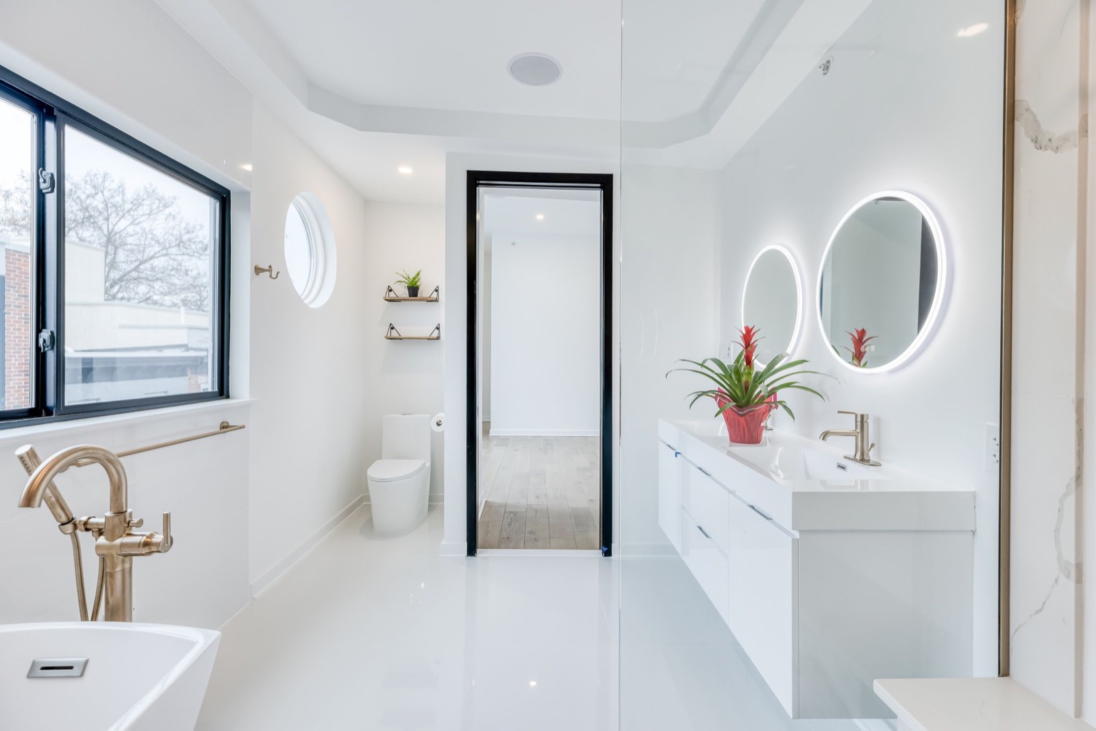 Bright master bath with brass tub filler and double vanity