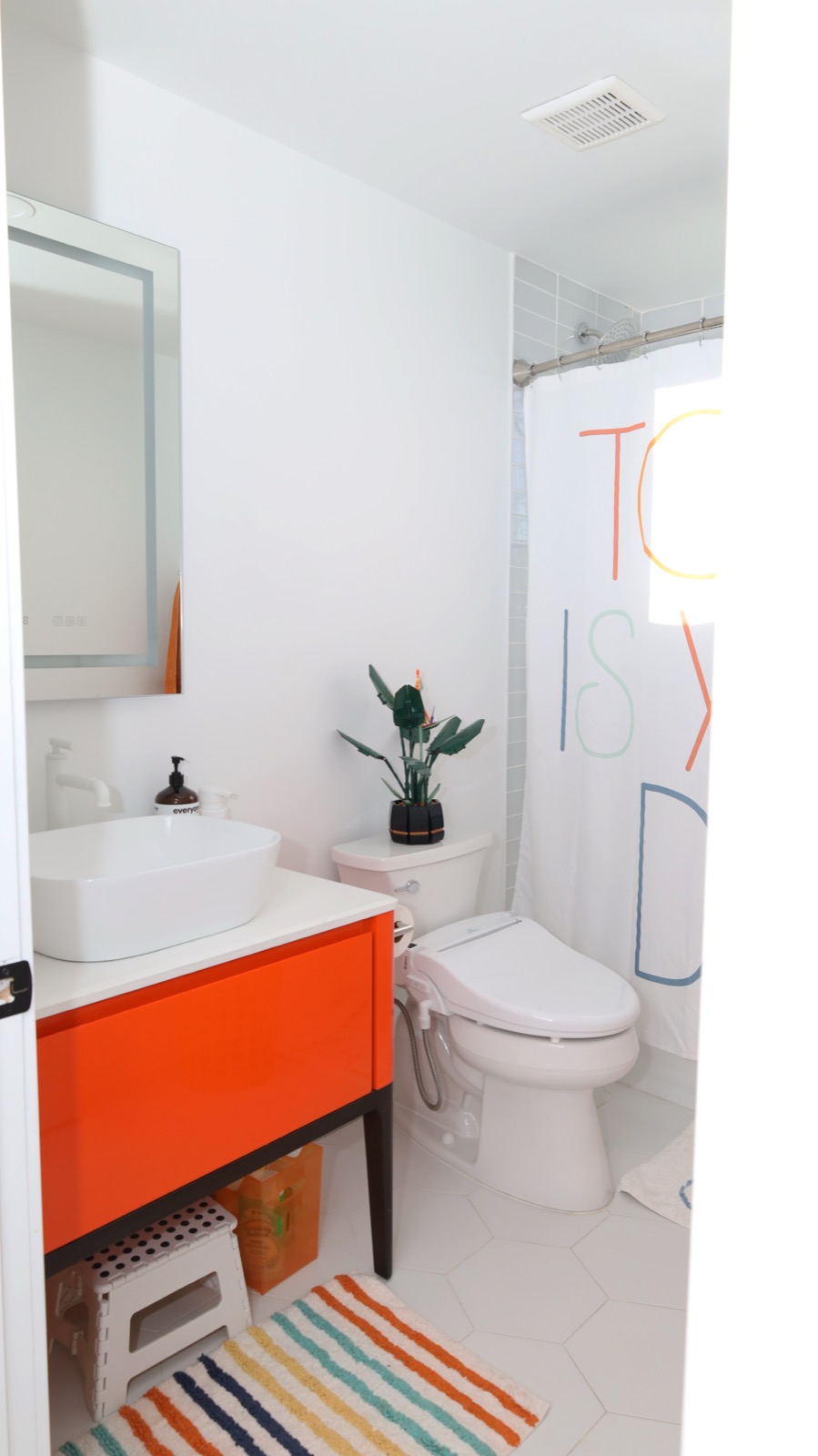 Colorful kids bathroom with orange vanity and vessel sink