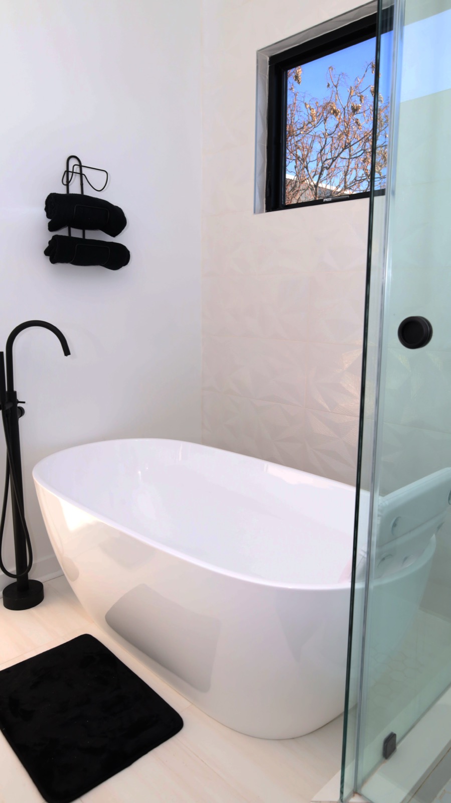 Freestanding soaking tub under a bright window