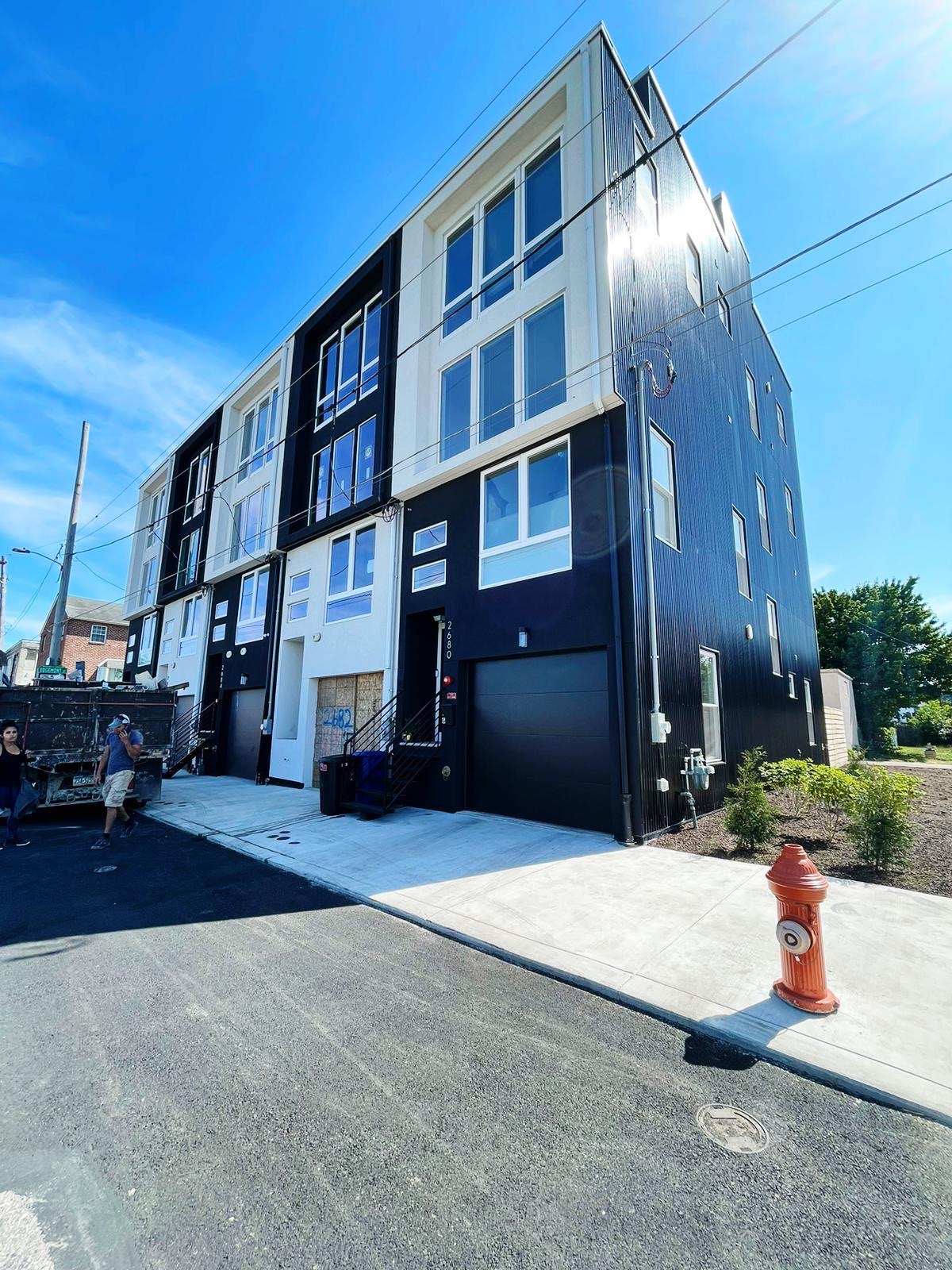Completed corner townhome with garage and new sidewalk in Port Richmond