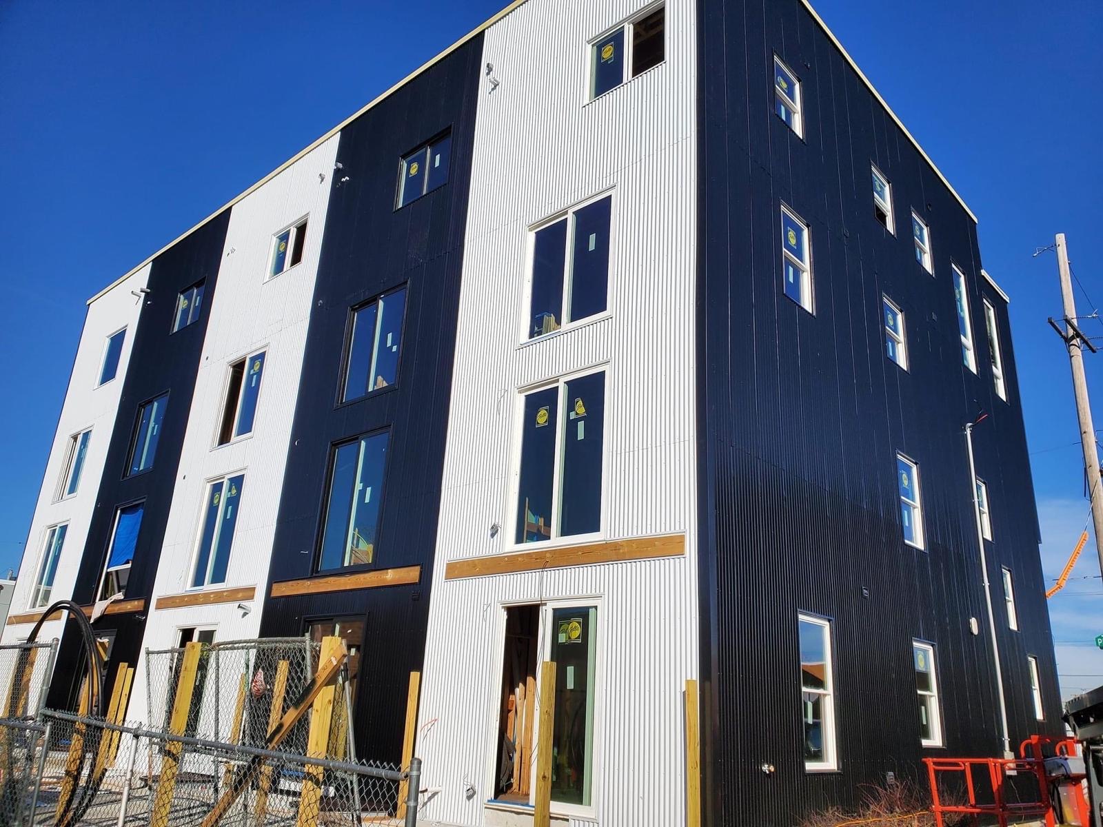 Close-up of the black and white corrugated facade with new windows