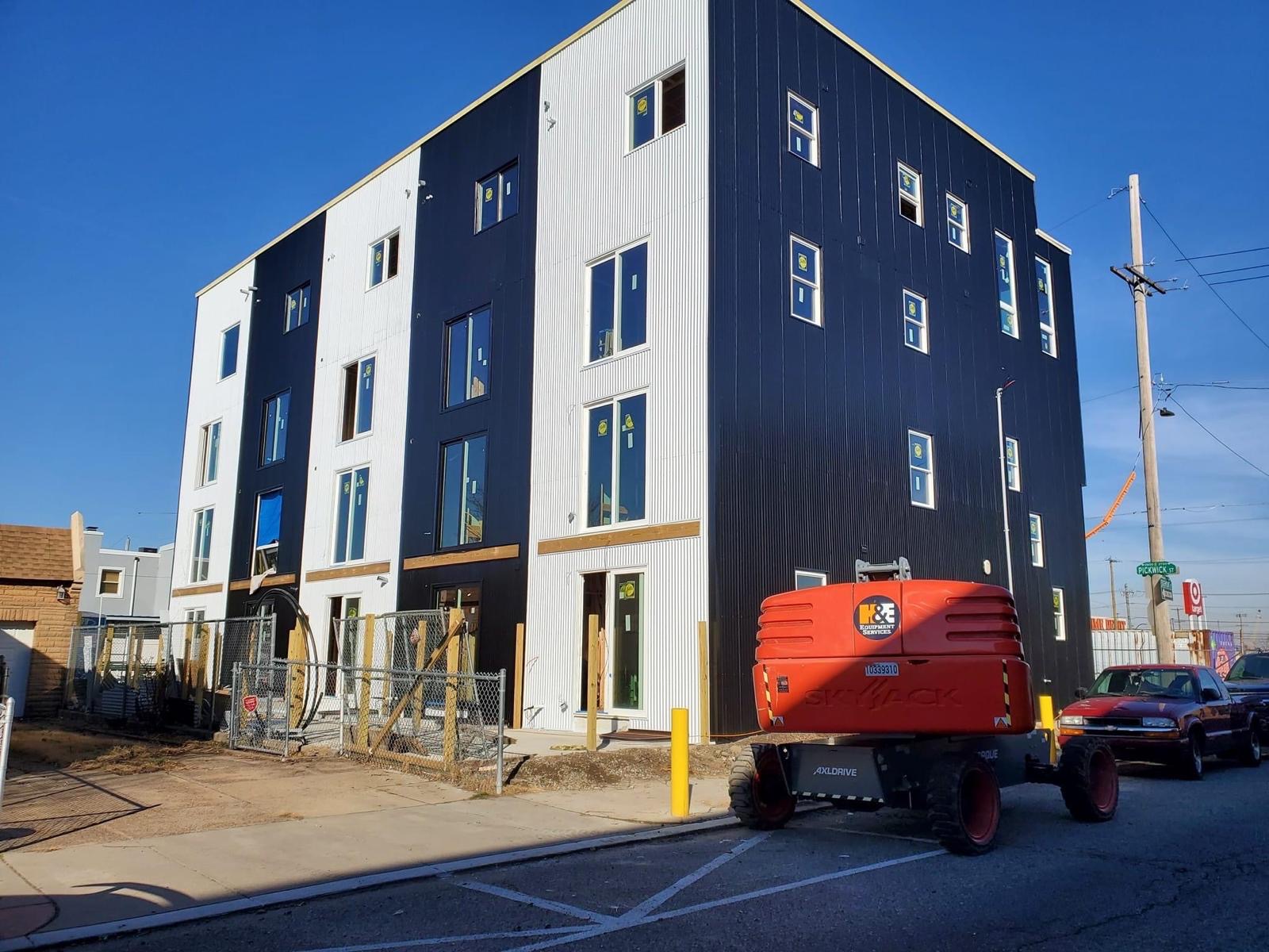Boom lift working the corrugated facade mid-construction