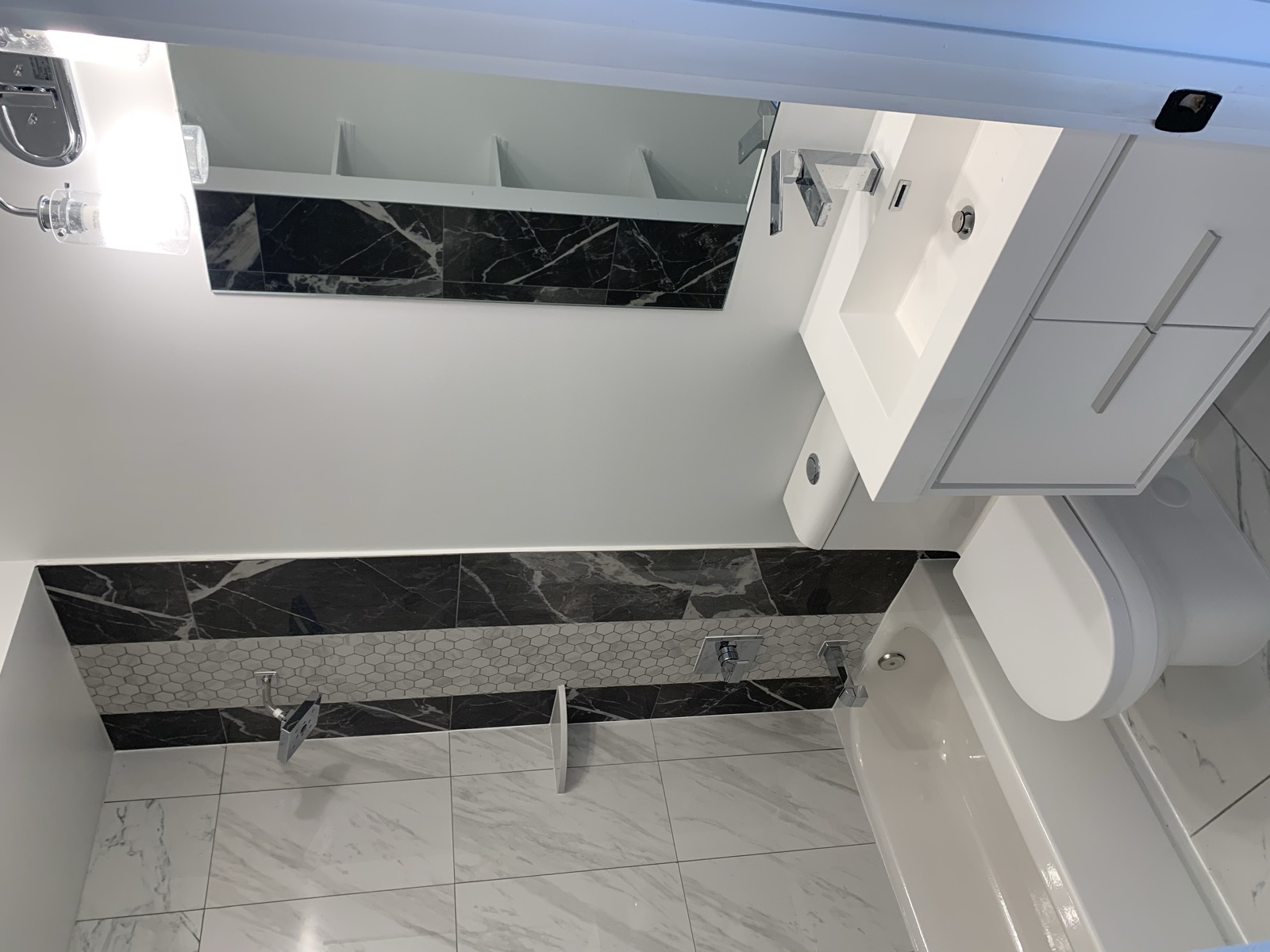 Bathroom with black marble accent wall and floating vanity