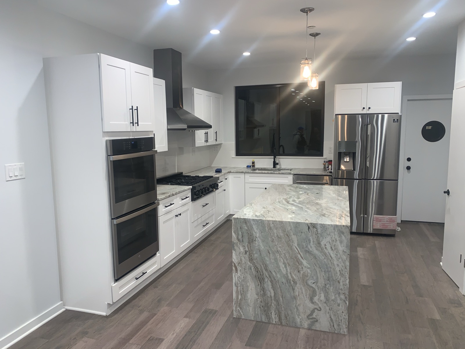 Waterfall granite island with pendant lights