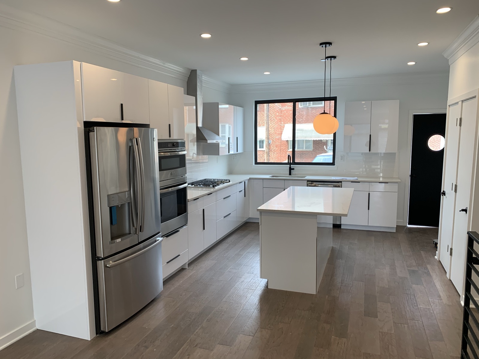 White kitchen with island pendant light and rear entry