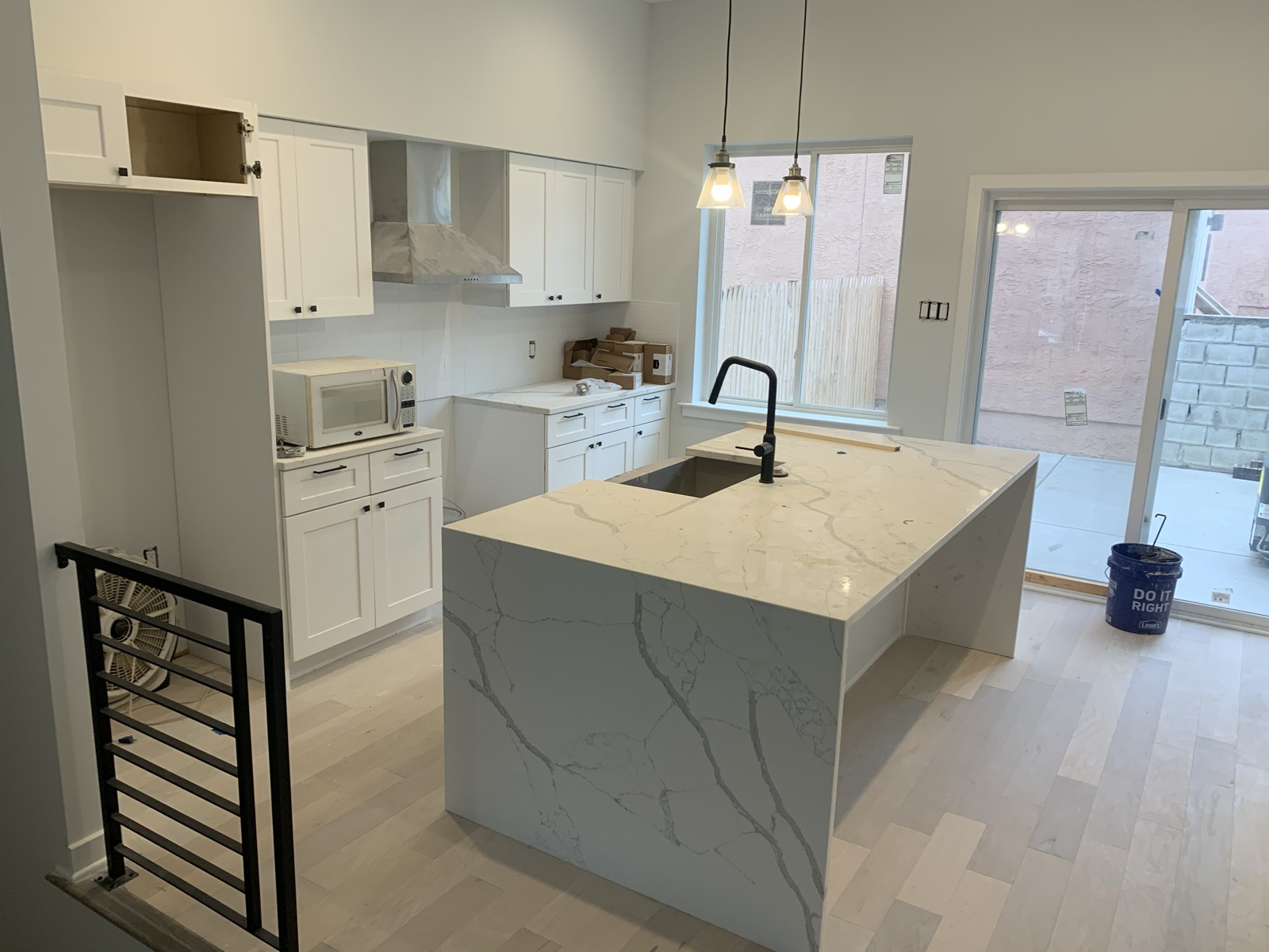 Kitchen with quartz waterfall island and black faucet