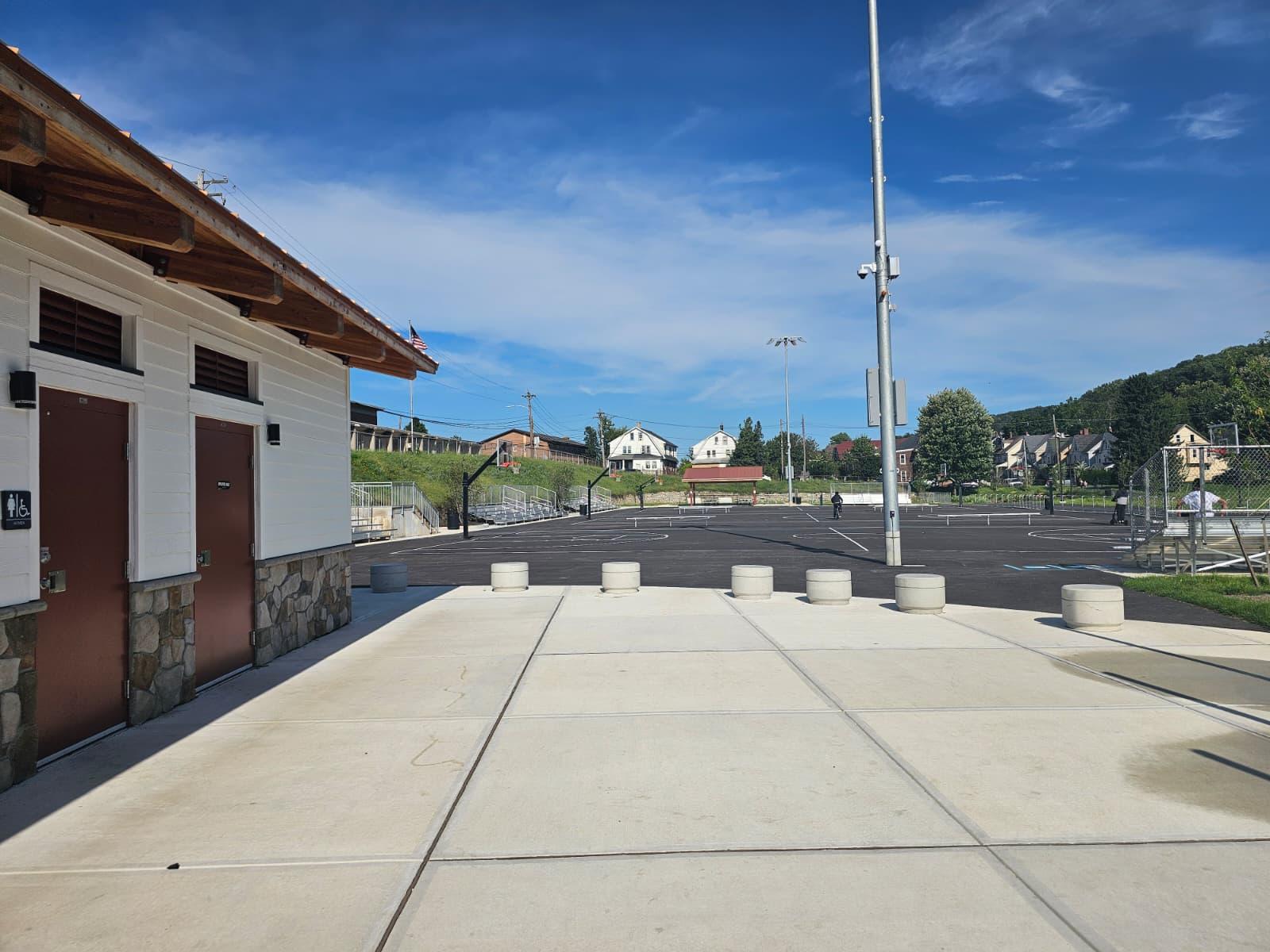 Concrete flatwork and precast bollards meeting the parking lot