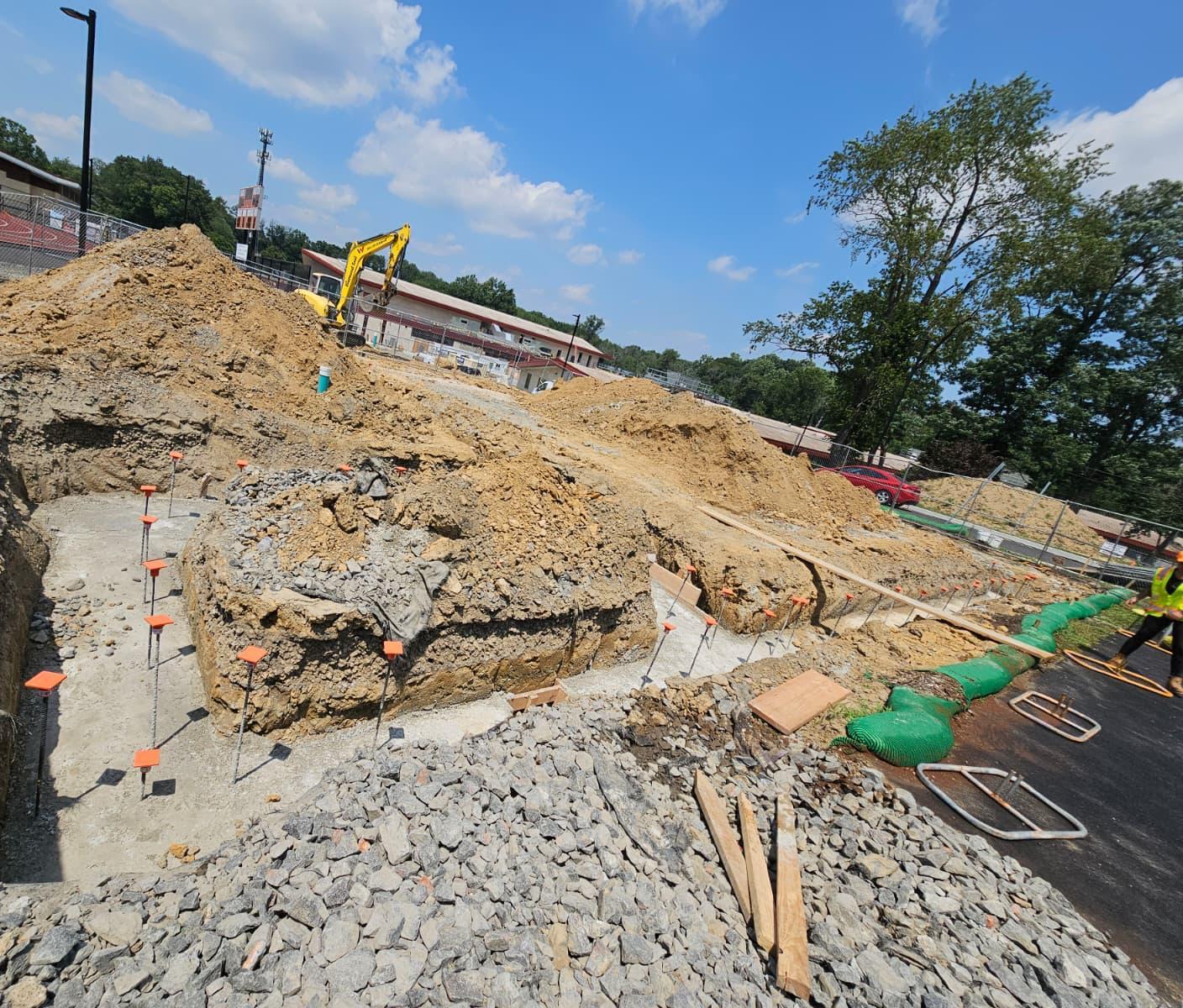 Poured footing with capped dowels beside the stone construction entrance