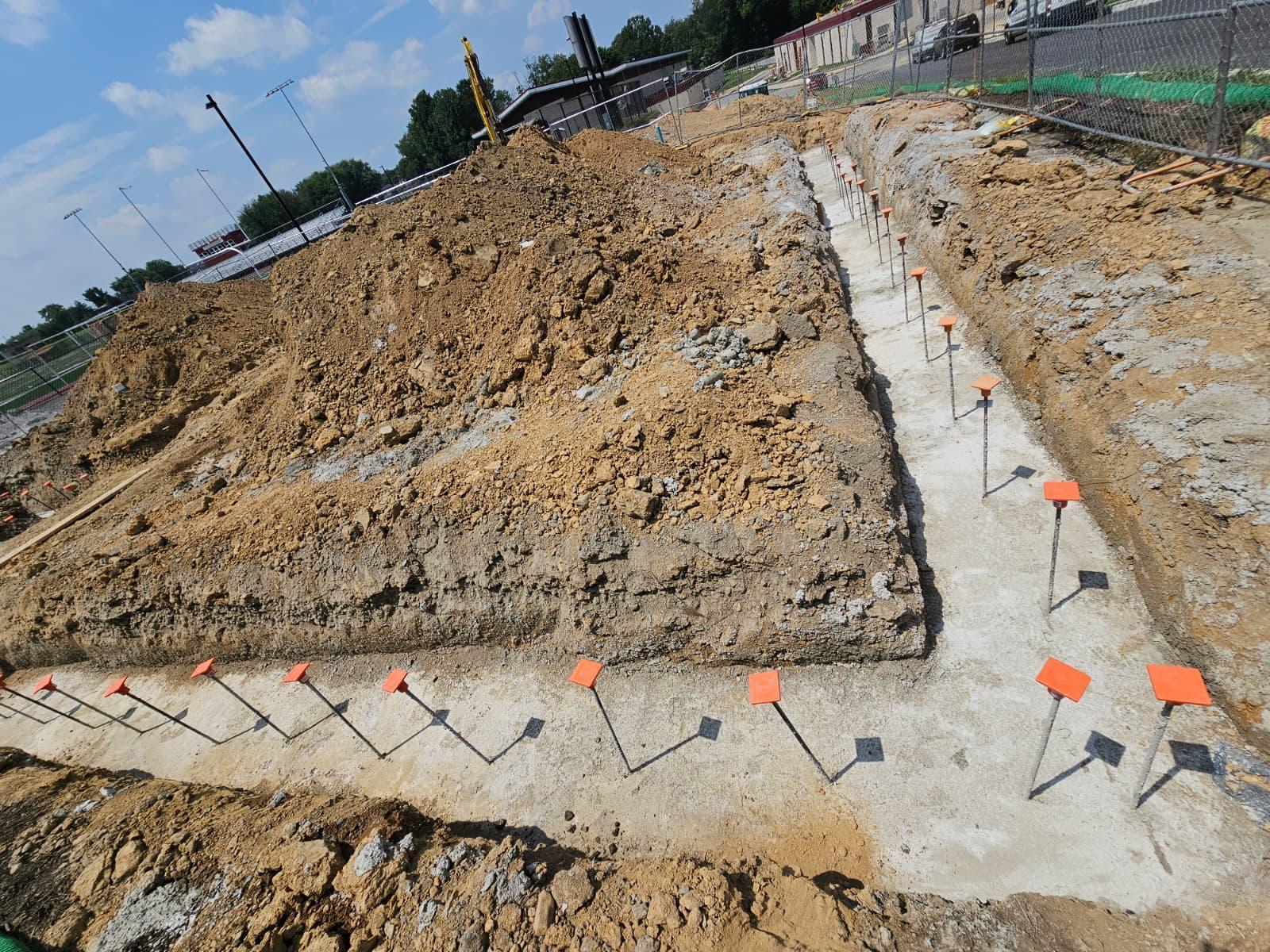 Poured concrete footings with capped rebar dowels