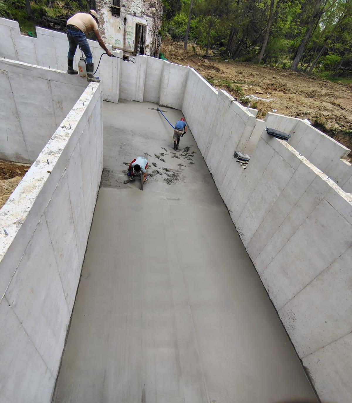 Crew finishing the basement slab between poured foundation walls