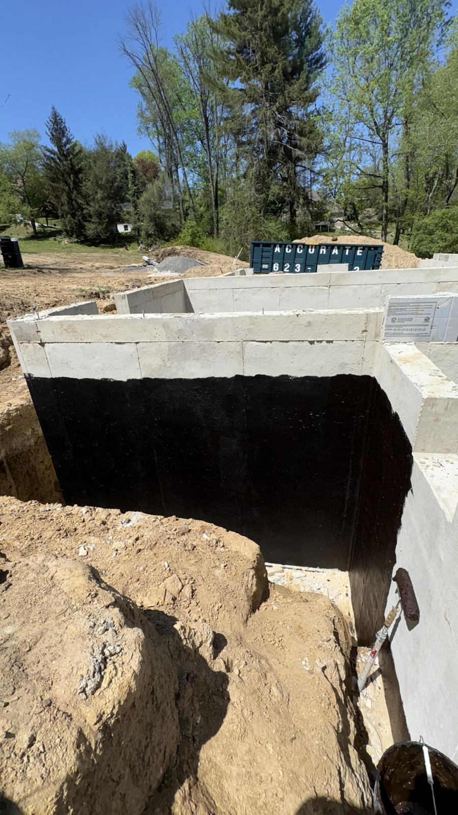 Poured foundation wall with dampproofing applied before backfill