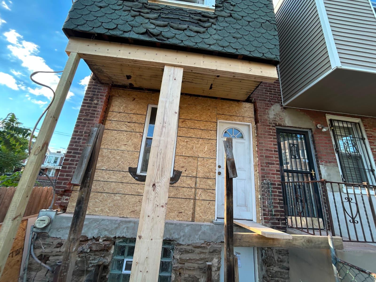 Before: rear wall sheathed in OSB with temporary shoring under the roof overhang
