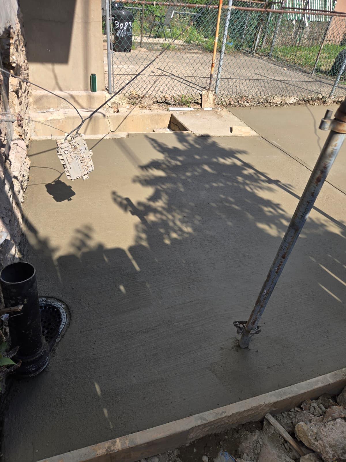 Rear yard concrete slab poured to the fence line around the drain cleanout