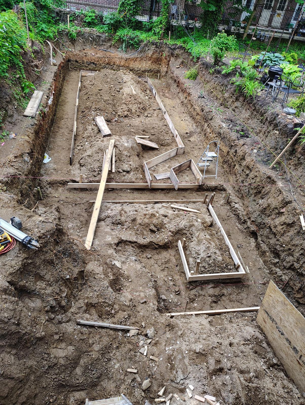 Footing formwork laid out in an excavated rear yard