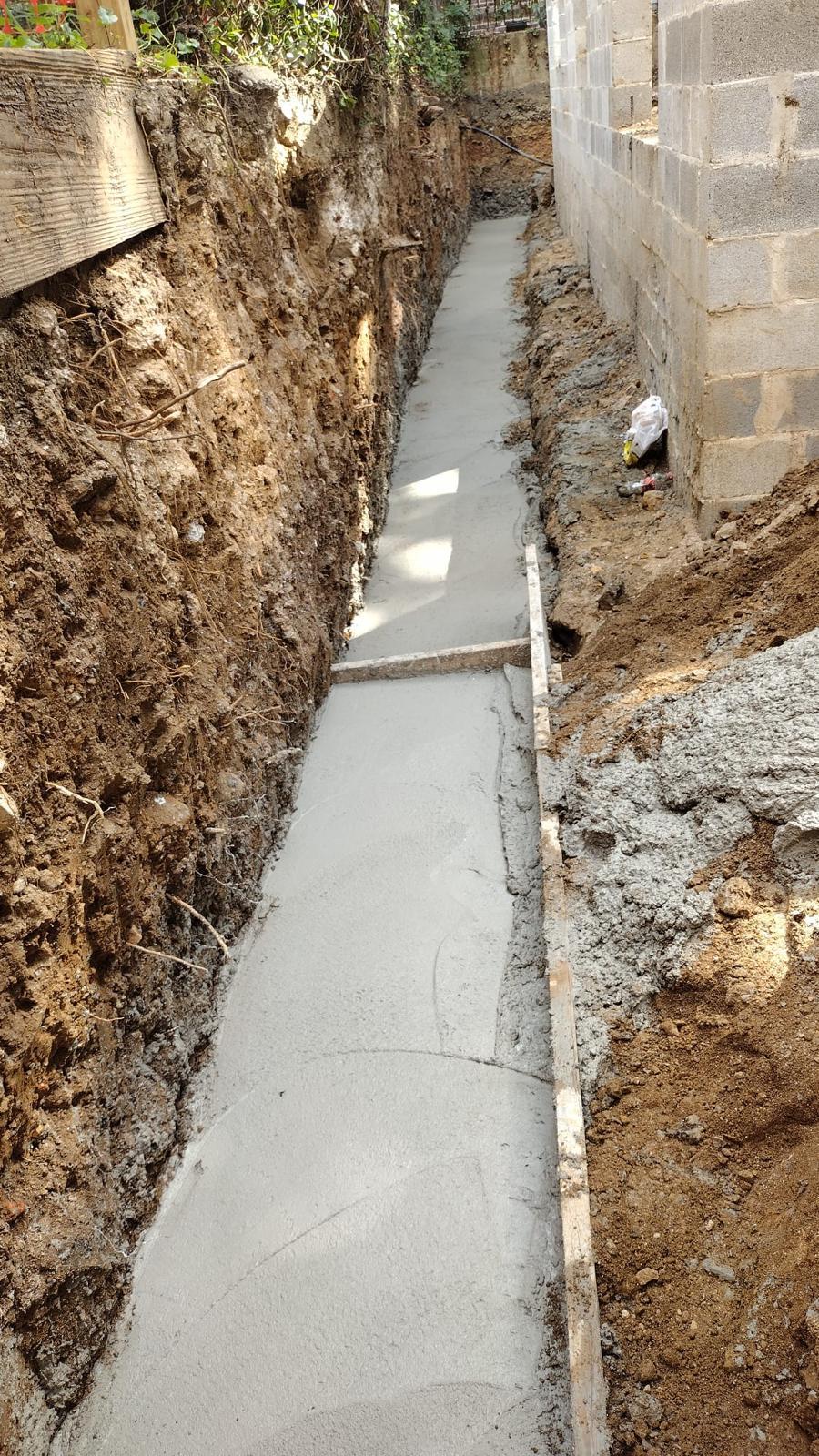 Trench footing poured alongside a block wall