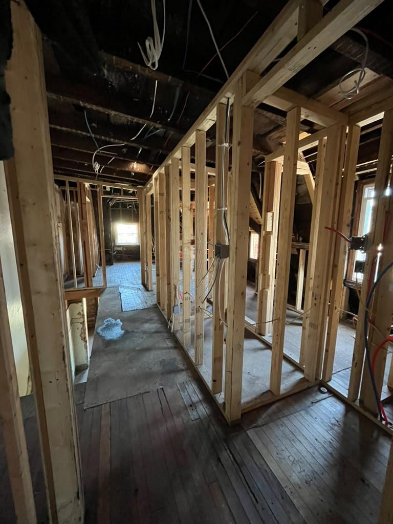 New stud partition walls framed along a hallway in a gutted rowhome