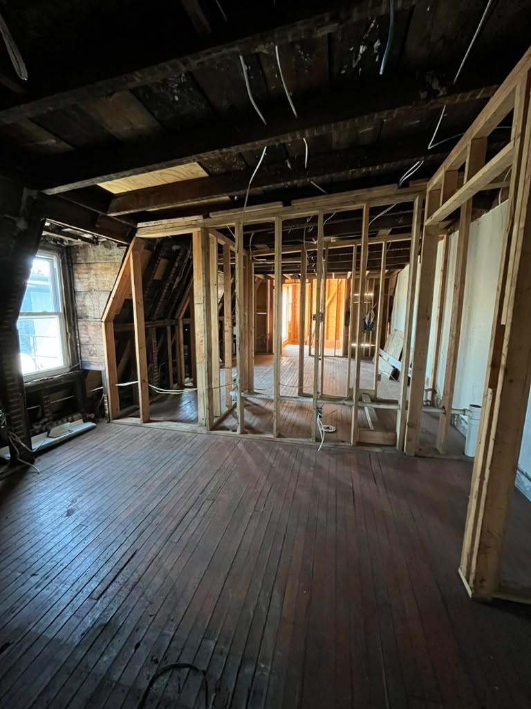 Interior stud walls framed over original plank floors under the old joists