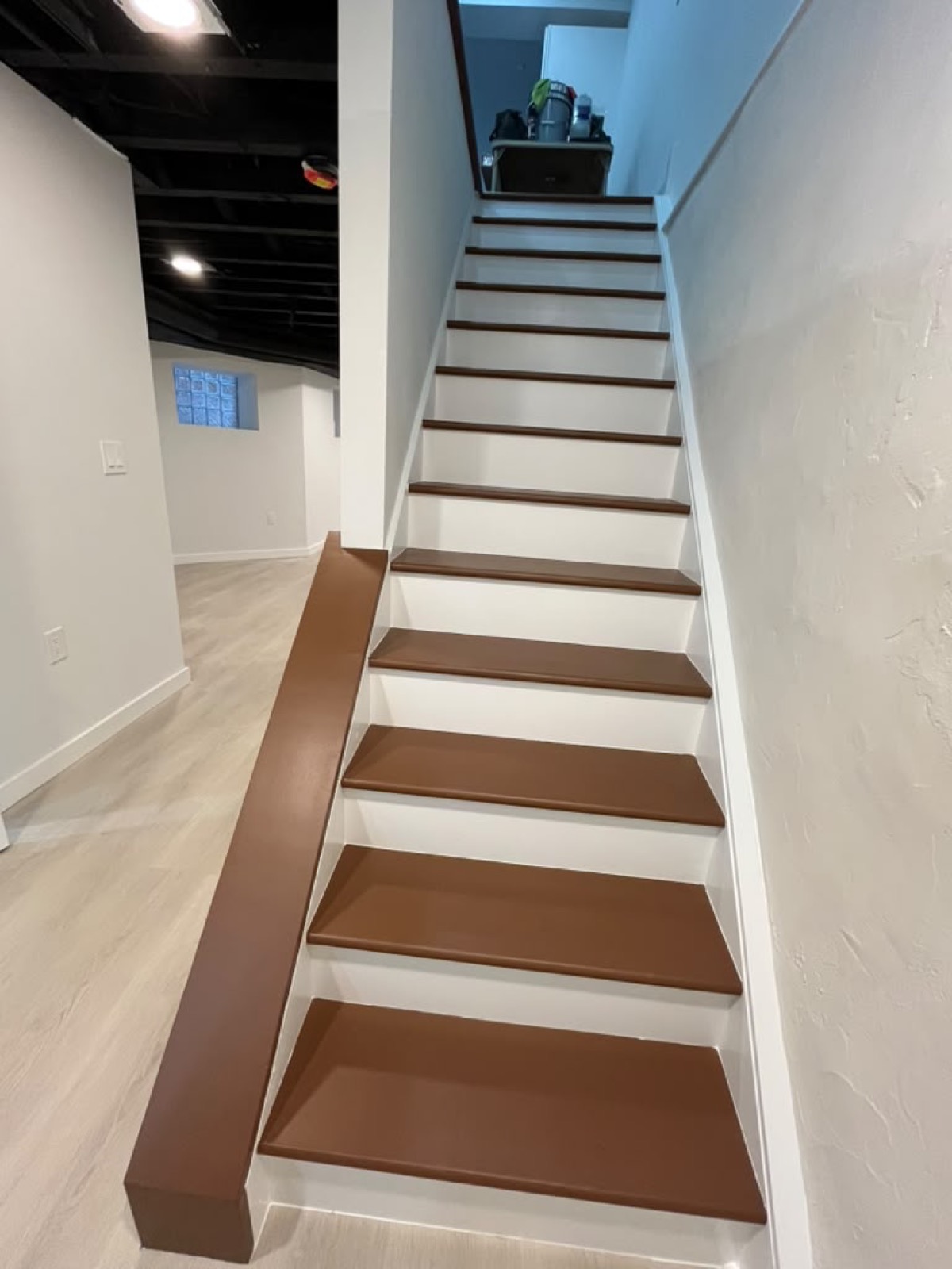 Finished basement staircase with brown treads and white risers