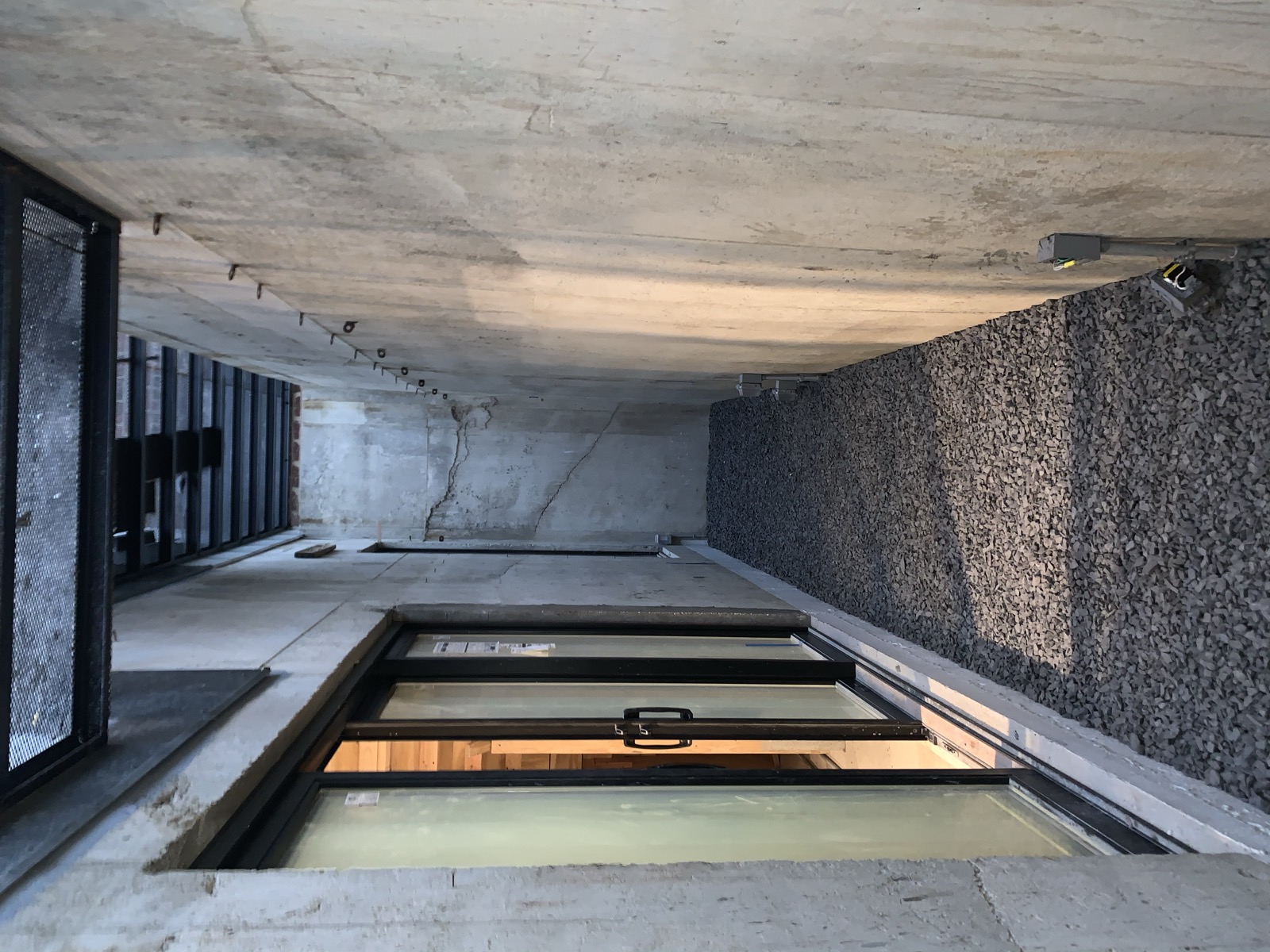 Poured concrete courtyard walls with steel catwalk above