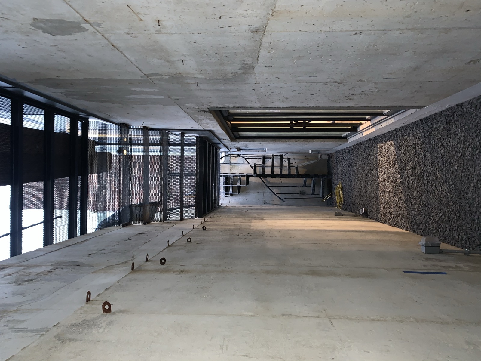 Concrete light-well courtyard with black steel spiral stair