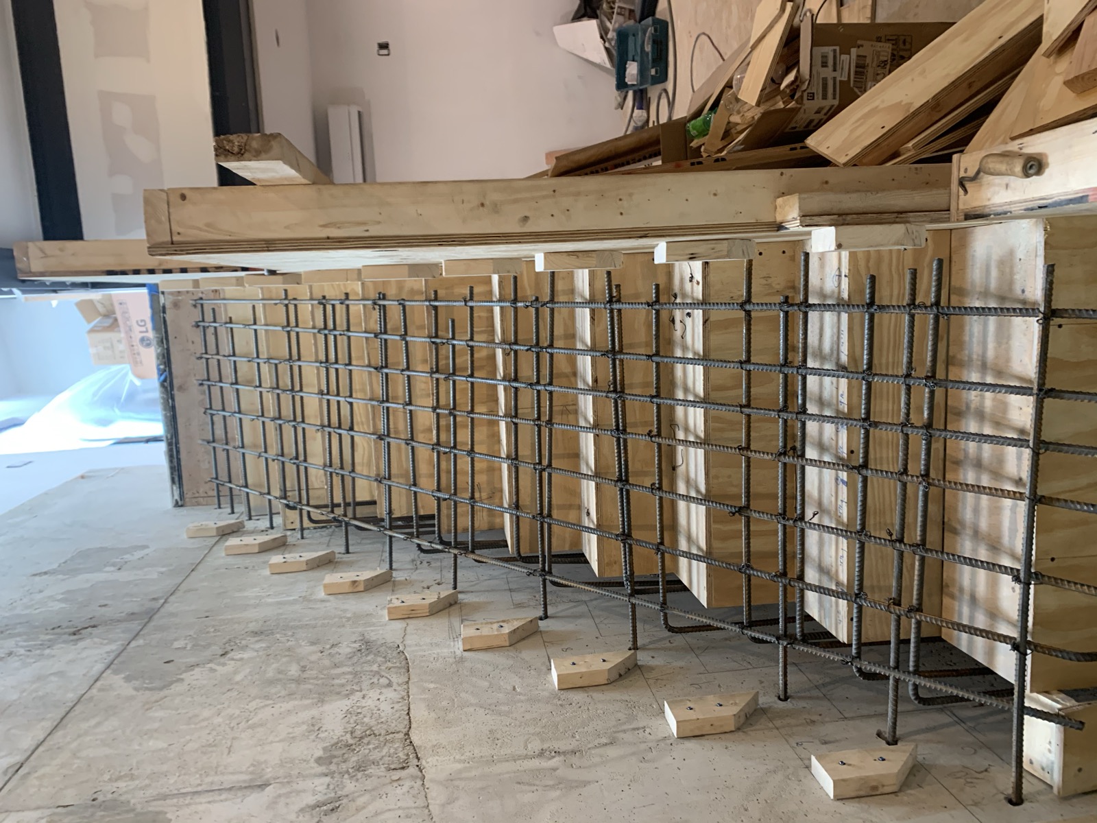 Rebar-reinforced concrete stair formwork against a board-formed wall
