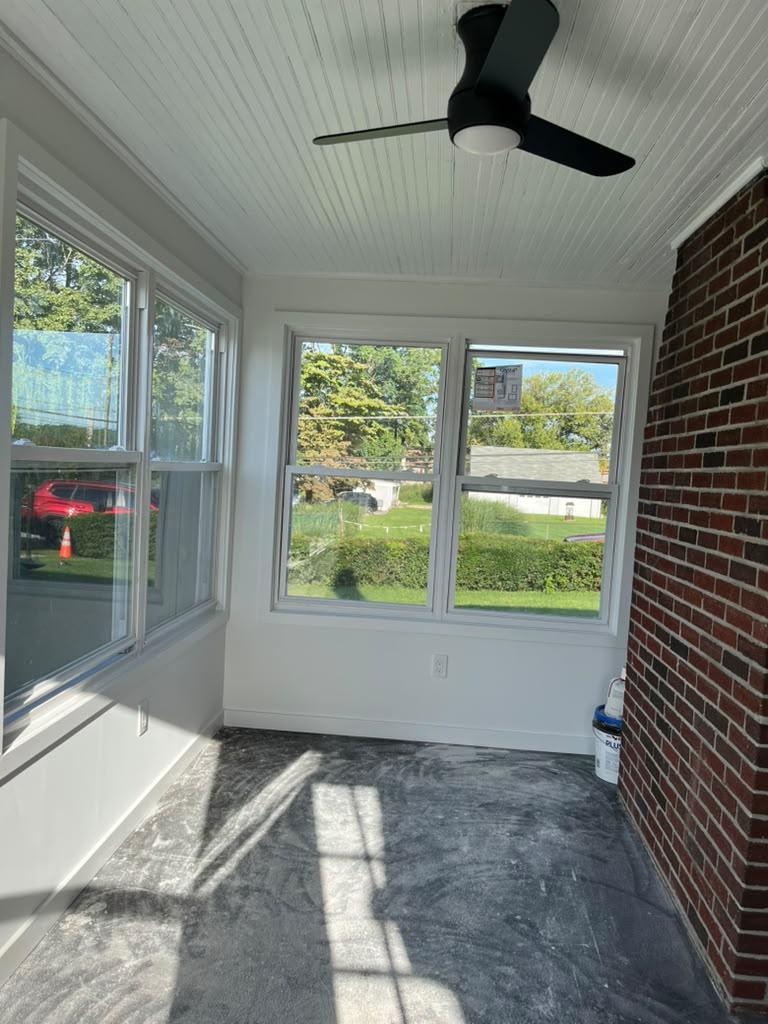 Finished sunroom with painted trim, new windows, and the original brick wall