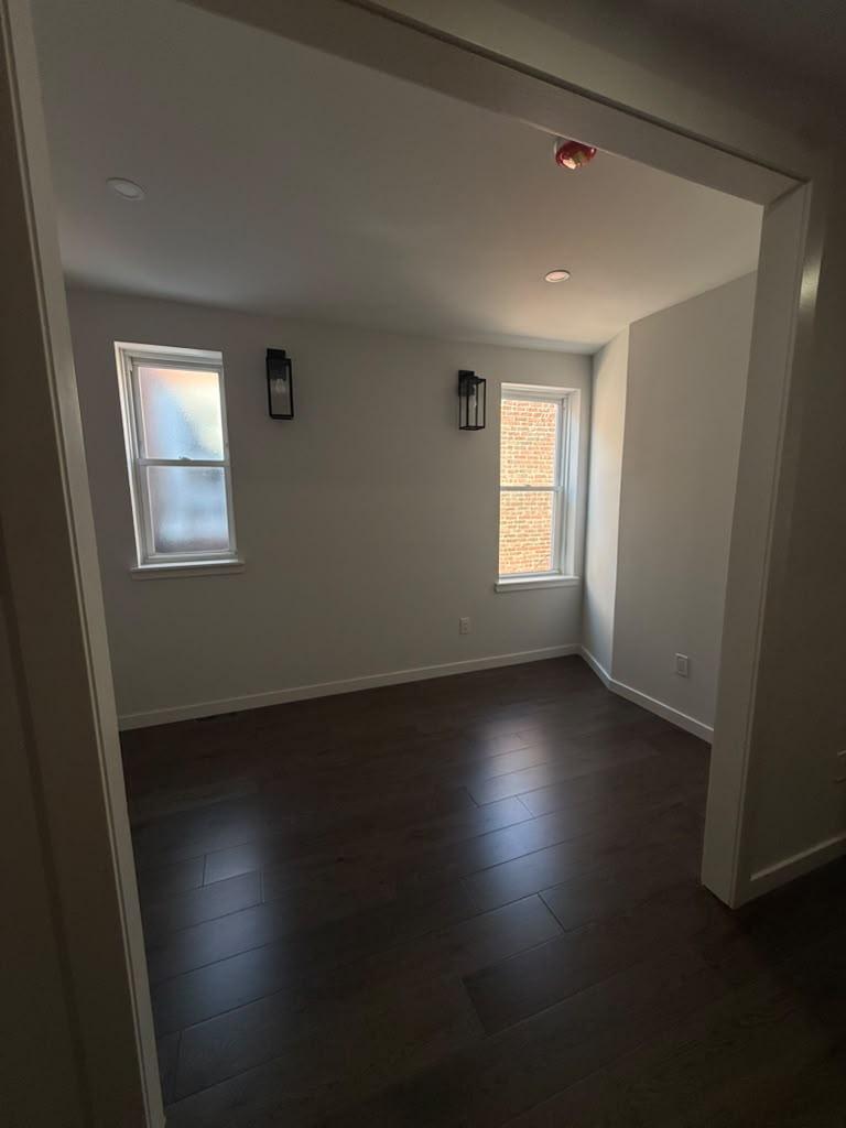 Bedroom with dark hardwood floors and black wall sconces