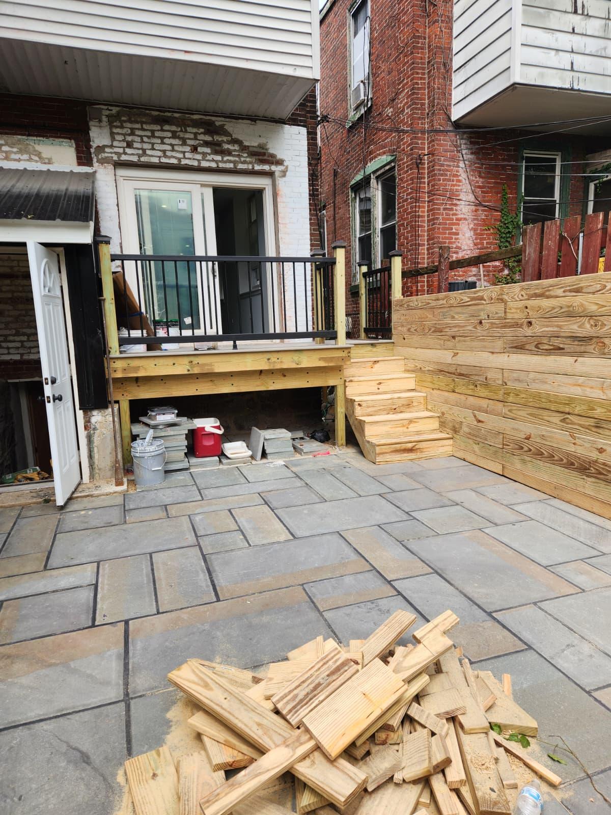 Bluestone patio with deck stairs and horizontal board fence